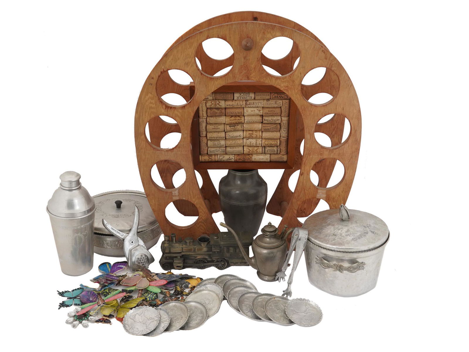 VINTAGE BARWARE COASTERS SHAKER AND DECOR ITEMS: A lot of vintage barware. A total of 24 items. An aluminum set with floral metalwork including a shaker, two ice buckets, tongs, 14 coasters. Irvin ware lime squeezer, horseshoe-shaped cork board, Man