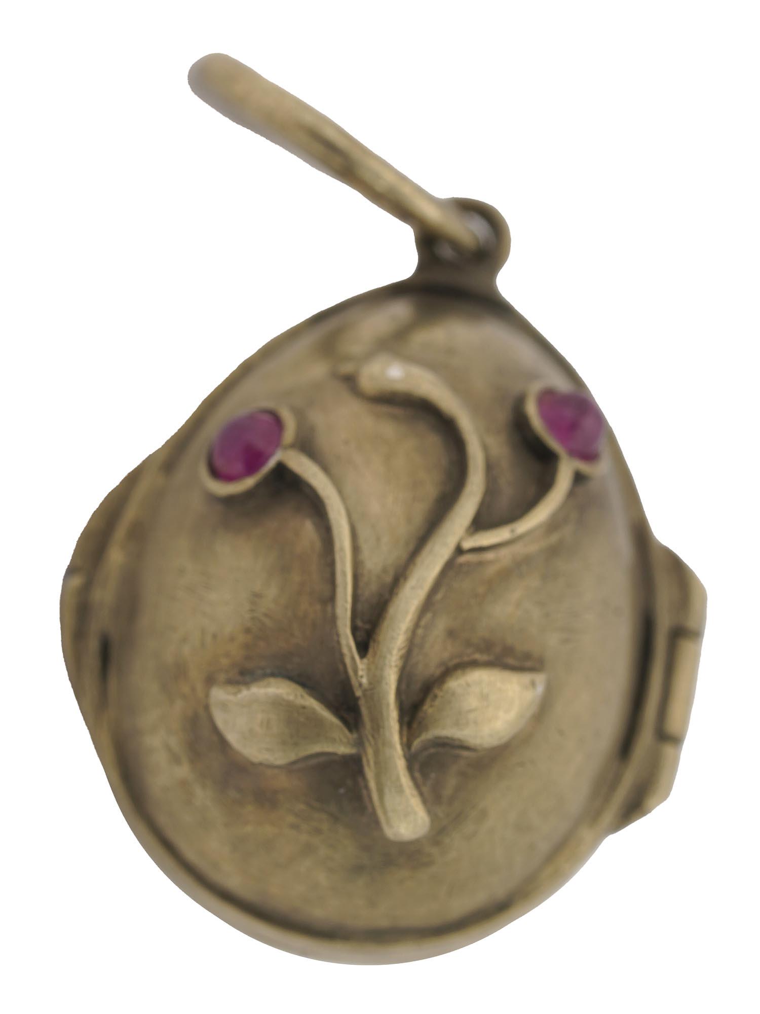 RUSSIAN GILT SILVER AND RUBY EGG LOCKET PENDANT: A Russian gilt silver egg-shaped locket pendant. Relief flowers on both sides are inset with ruby gemstones. Hallmark with 88 silver standard and makers mark are on the loop. Weight: 6.5 grams. Collec