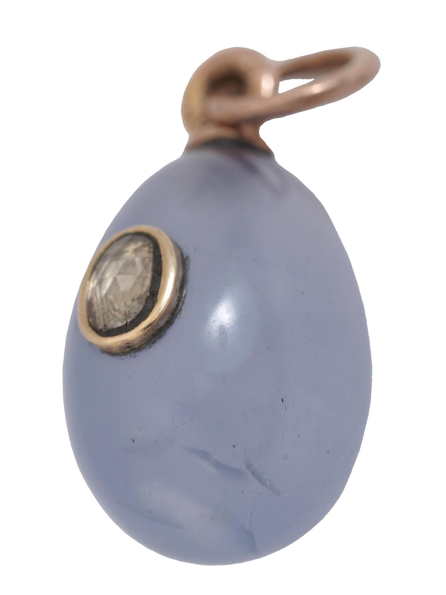 RUSSIAN GOLD, BLUE CHALCEDONY DIAMOND EGG PENDANT: A Russian gold mounted miniature egg pendant hand carved of natural blue polished chalcedony and set with a round cut diamond in a 14K gold setting. Marked on the suspension ring with 56AP zolotnik Im
