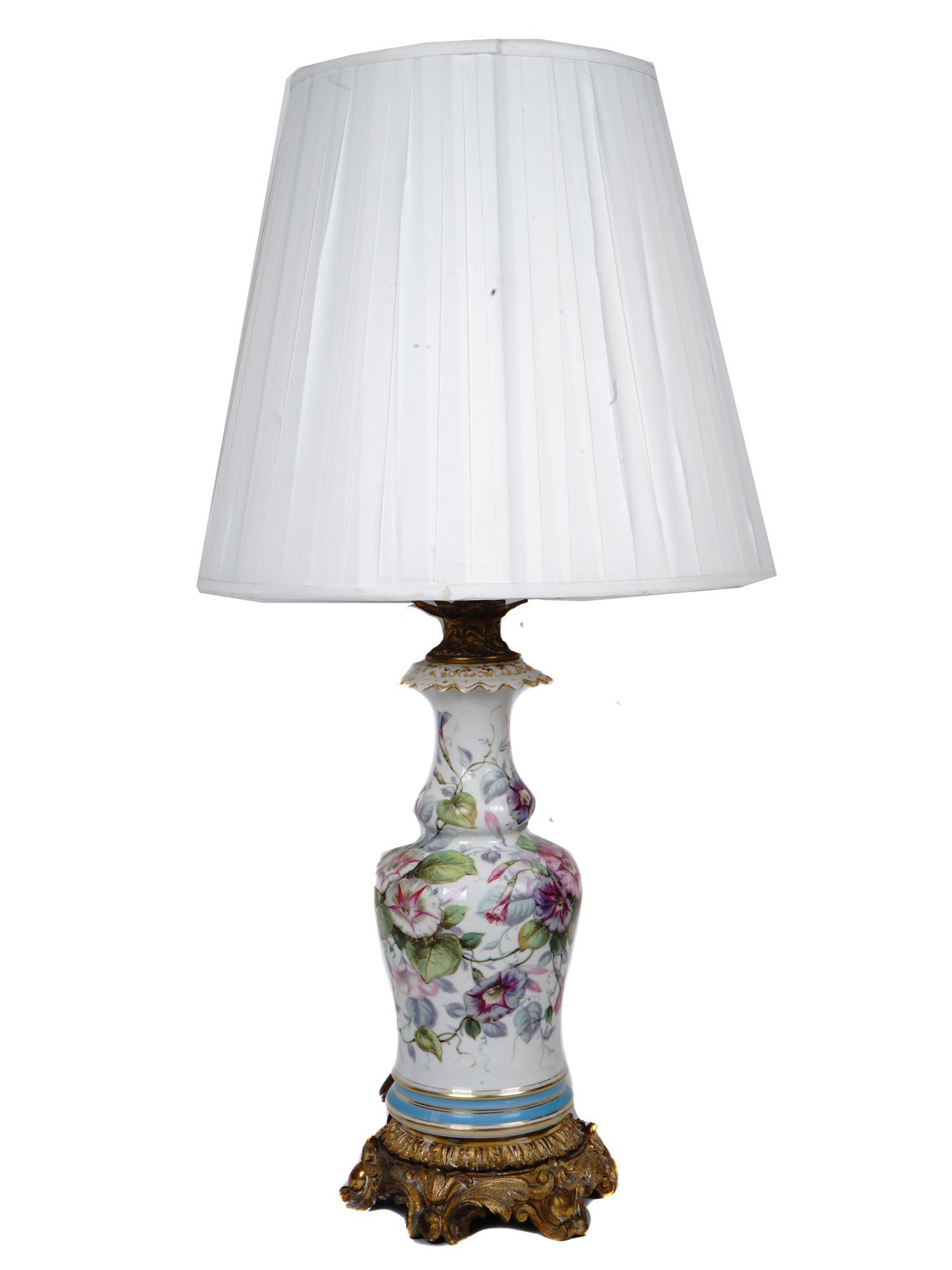 ANTIQUE SEVRES PORCELAIN PAINTED URN TABLE LAMP: An antique French Sevres porcelain urn that was professionally converted to a table lamp with bronze mounts and a custom shade. The urn is decorated with hand painted flowers. Circa the late 19th cent