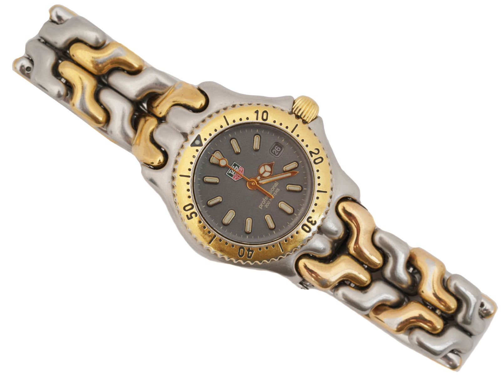 RARE TAG HEUER GILT STAINLESS STEEL WRIST WATCH: A vintage stainless steel ladies wristwatch by Tag Heuer, a Swiss clock manufacturer. The black round dial with baton indexes and subdial has luminous hands and markers, as well as the Tag Heuer monog