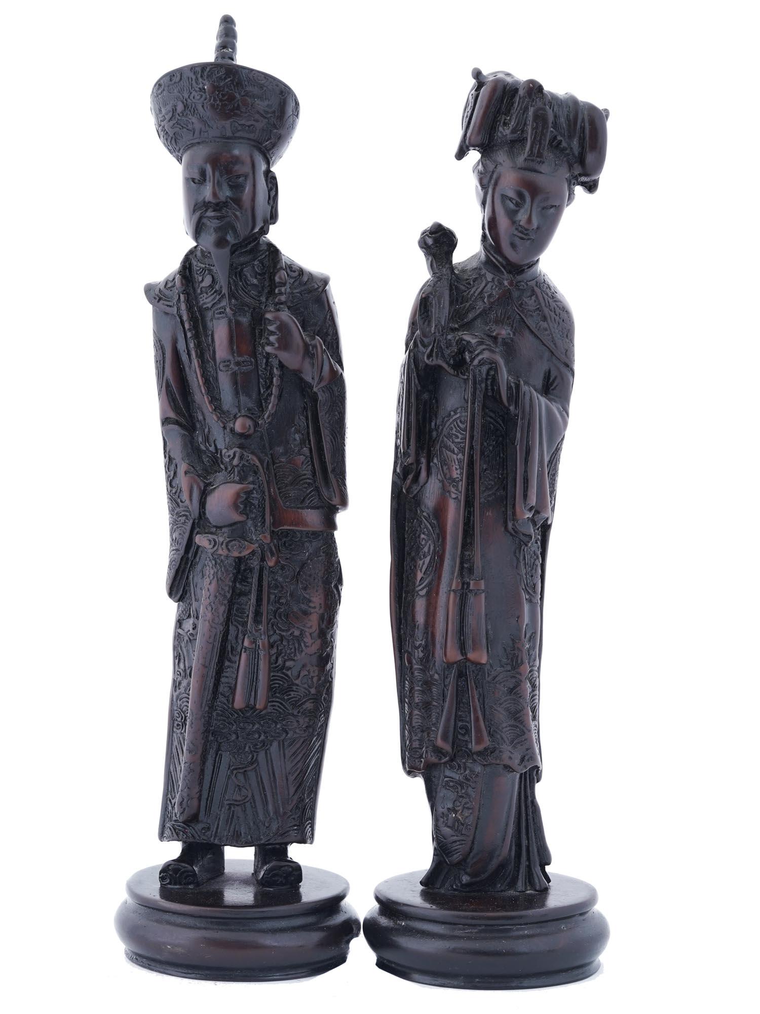 PAIR OF CHINESE HAND CARVED WOOD HUMAN FIGURINES: A pair of hand-carved redwood figurines representing a Chinese man and woman in traditional clothing. Fine detail work. The pieces are lacquered and placed on round bases. Oriental Decor Sculpture For