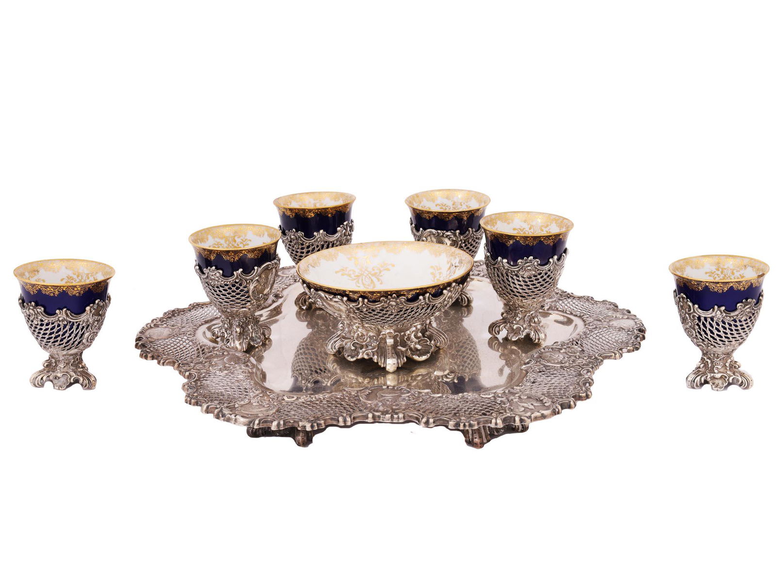 ANTIQUE MEISSEN PORCELAIN AND SILVER EGG CUPS SET: A very high quality antique porcelain and silver egg cups set composed of six German Meissen porcelain egg cups and a bowl, filigree silver holders for cups and bowl and a large silver tray with filig