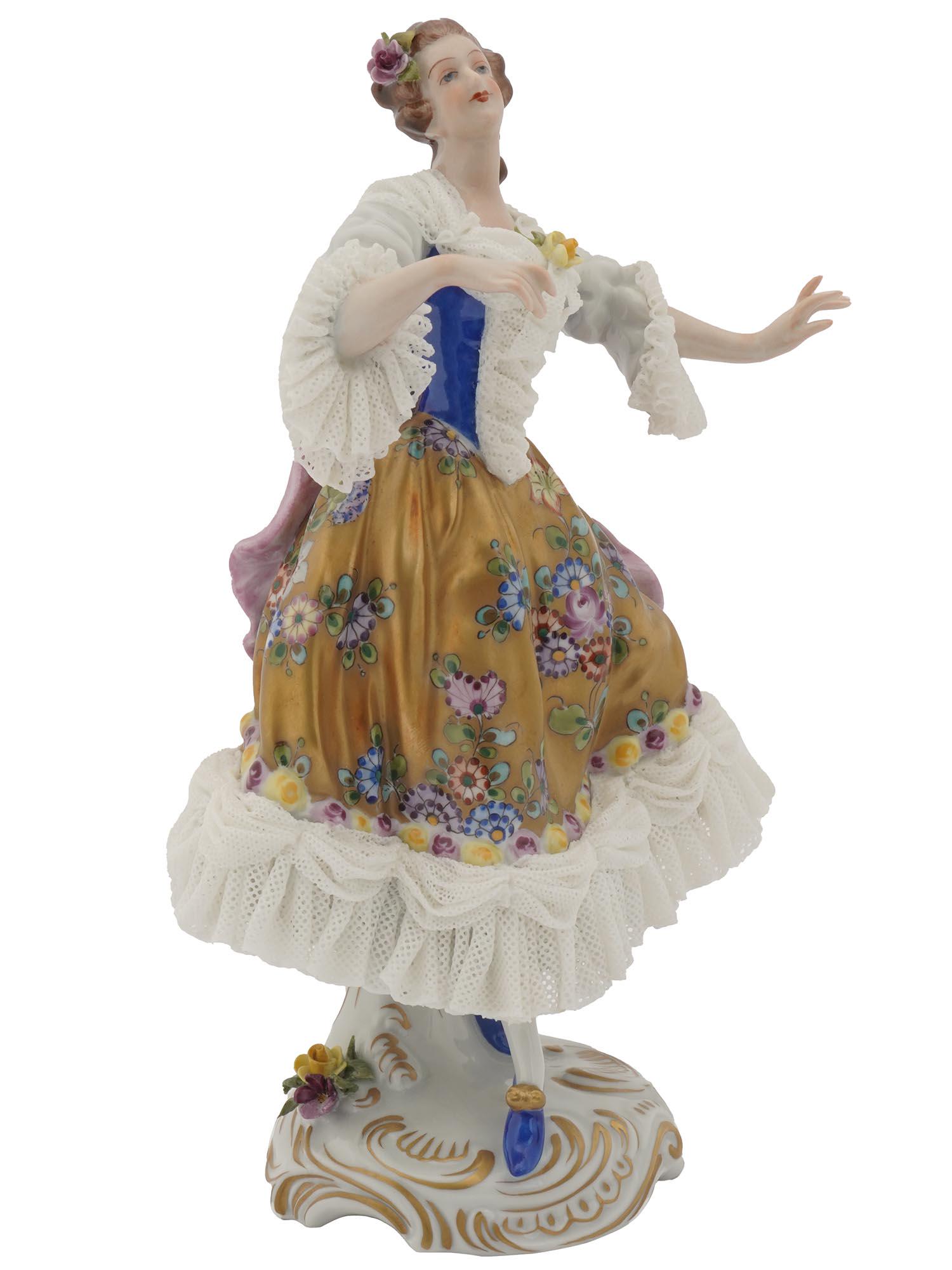 ANTIQUE DRESDEN VOLKSTEDT LACE PORCELAIN LADY: An antique German Dresden Volkstedt gilt porcelain lace figure manufactured in the Rococo style depicting a racing lady in a ball gown dress hand painted in strong colors and lace trimmed. Circa the l