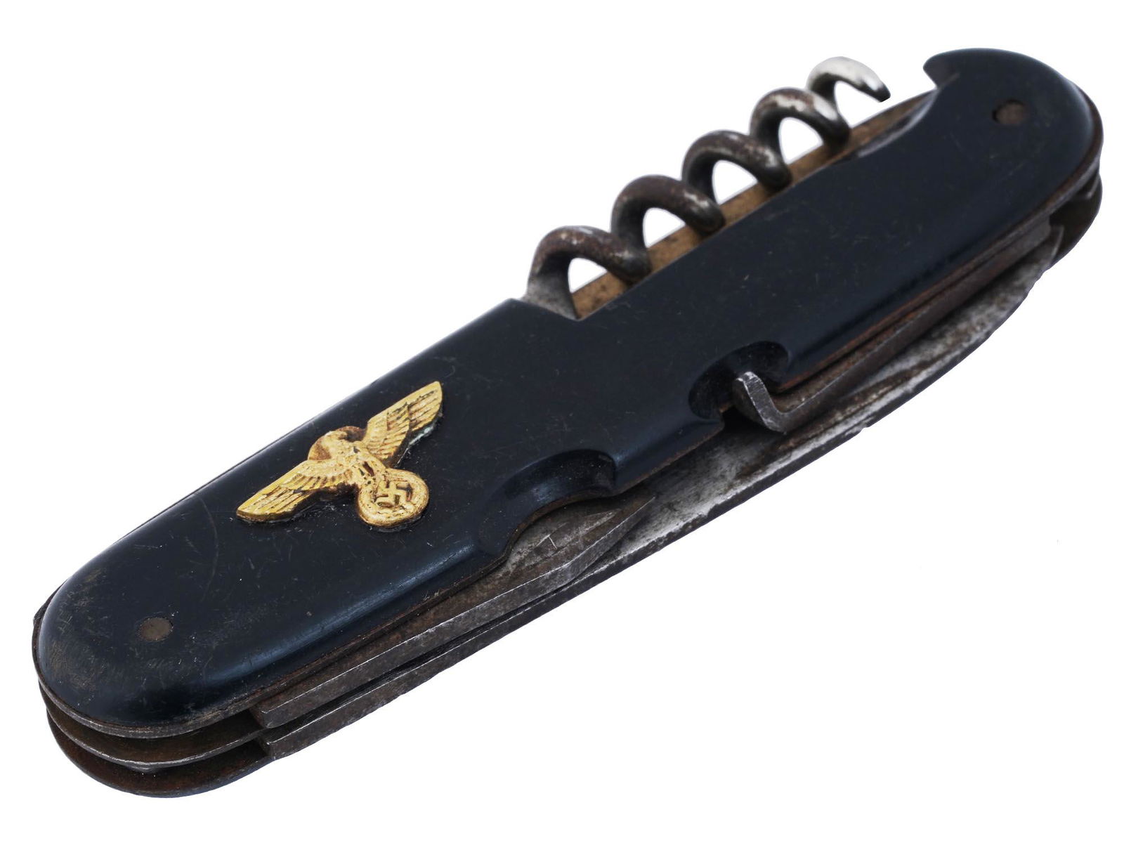 NAZI GERMAN WWII PARTY EAGLE FOLDING POCKET KNIFE: A Nazi German WWII folding pocket knife featuring a gilt Imperial Eagle, or Parteiadler of the Nazi Party, with head looking on its left, to the case. A knife blade marked Germany. Has various tools i