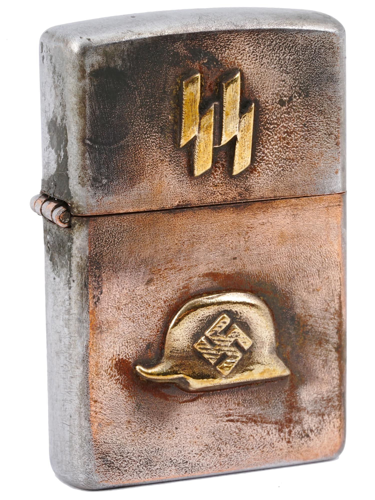 NAZI GERMAN WWII SS WAFFEN CIGARETTE LIGHTER: A Nazi German WWII SS Waffen cigarette lighter. The zippo style lighter adorned with affixed to a helmet swastika insignia to the center and SS runes on top. Marked with a stamp, an RZM mark to the bo