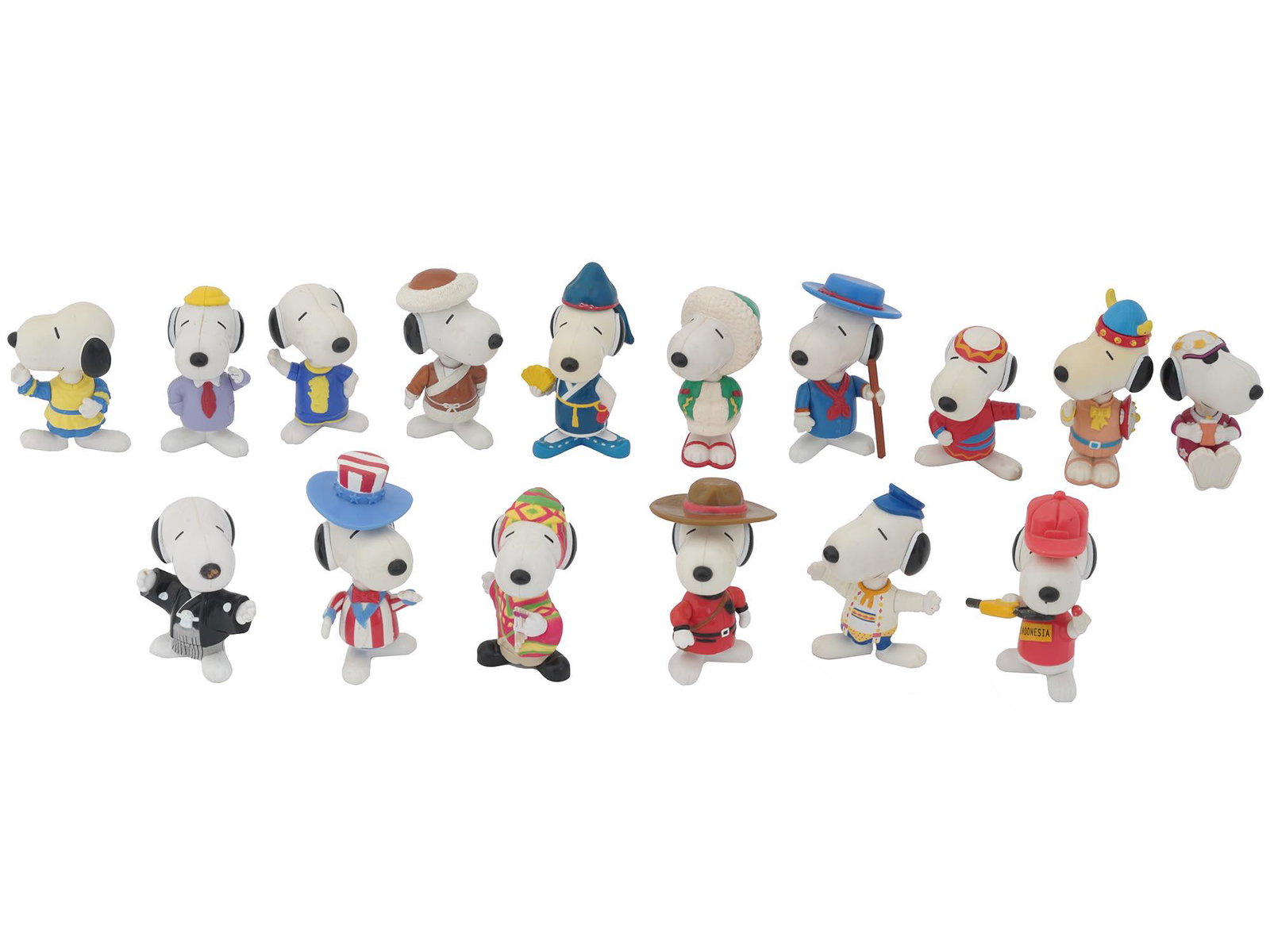 SIXTEEN SNOOPY MCDONALDS WORLD TOUR FIGURINES SET: A Snoopy McDonalds World Tour set of sixteen plastic figurines. Each figurine is presented in the characteristic costumes. The costumes present various countries. Circa: 1998. Snoopy is an anthropomor