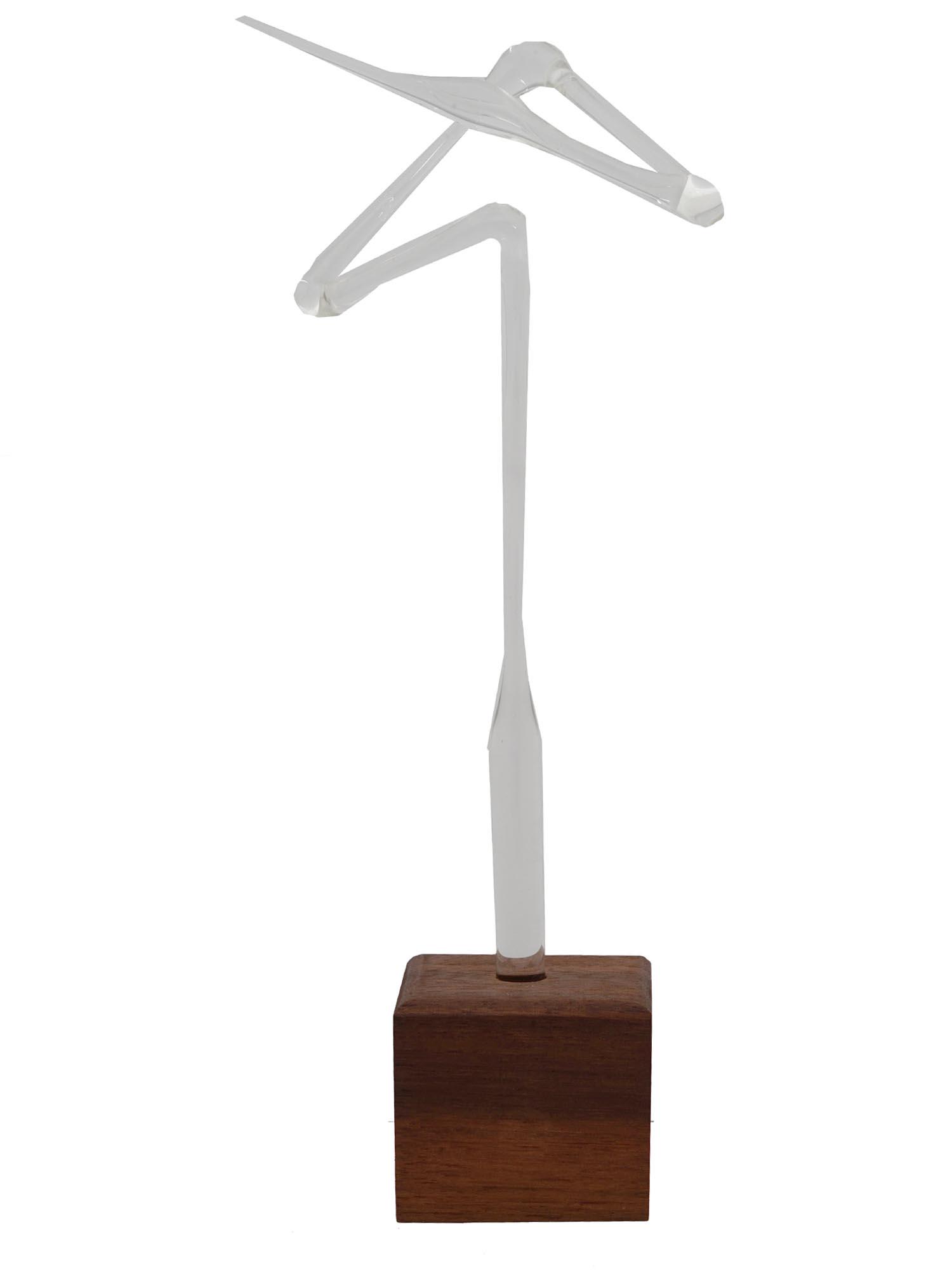 ABSTRACT CLEAR BLOWN GLASS FIGURE ON WOODEN BASE: An abstract transparent blown glass sculpture representing a geometric curve. The piece is mounted on a square wooden base. Home Decor And Sculpture For Interior Design. Dimensions: H 9 1/4 in. All me