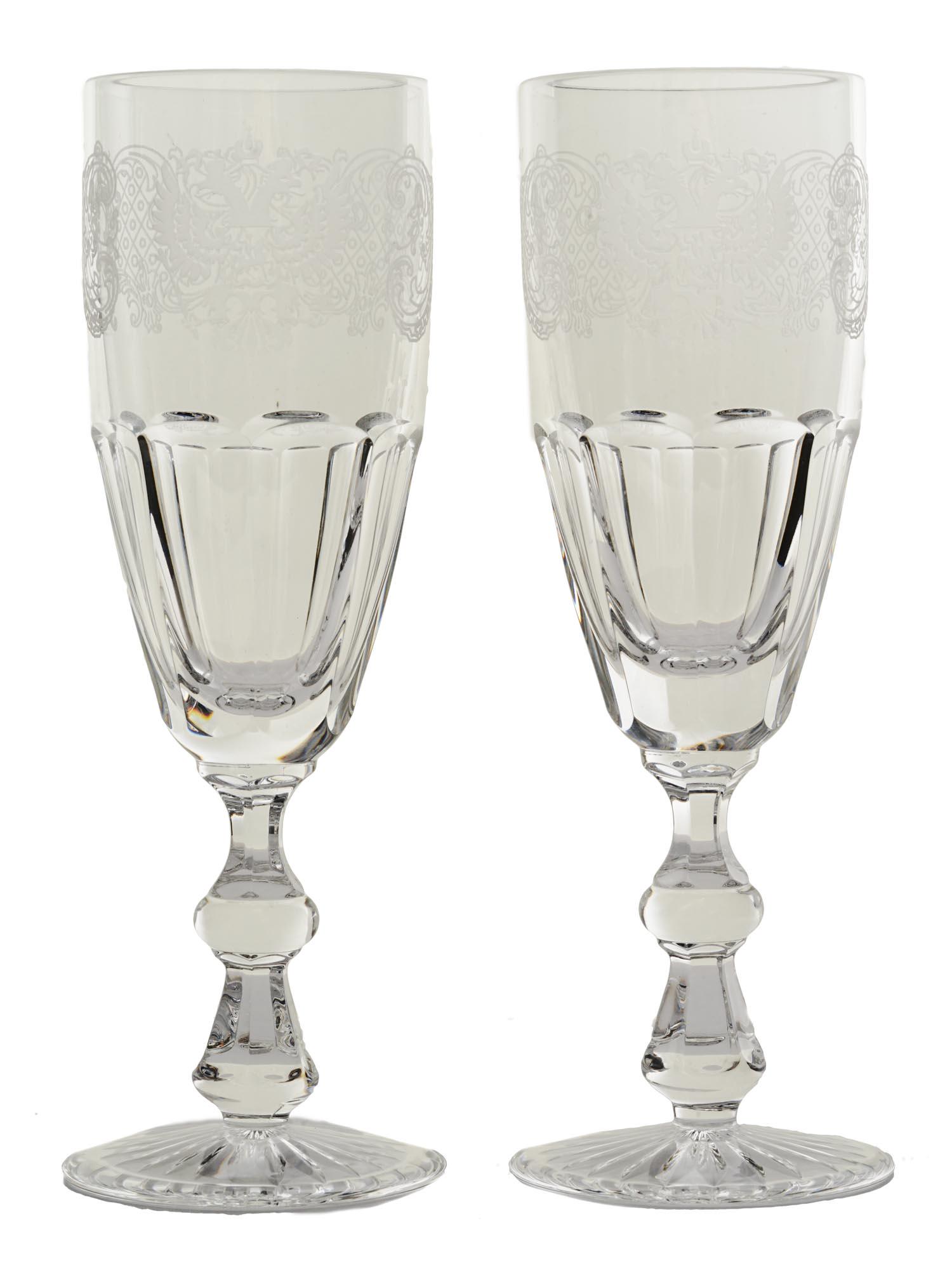 IMPERIAL RUSSIAN ETCHED CRYSTAL CHAMPAGNE GLASSES: A pair of Imperial Russian crystal champagne glasses. The bowl of each piece is faceted on the bottom, the upper part is hand-etched with a crowned double-headed eagle and ornamental decor. Antique Gl