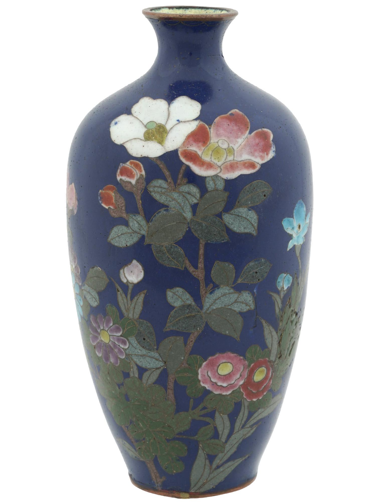 JAPANESE LATE MEIJI BLUE CLOISONNE ENAMEL VASE: An antique Japanese copper vase with cloisonne enamel design against the dark blue background. Late Meiji period, before 1912. The vase has an rounded shape with pronounced neck. The body of the vase 