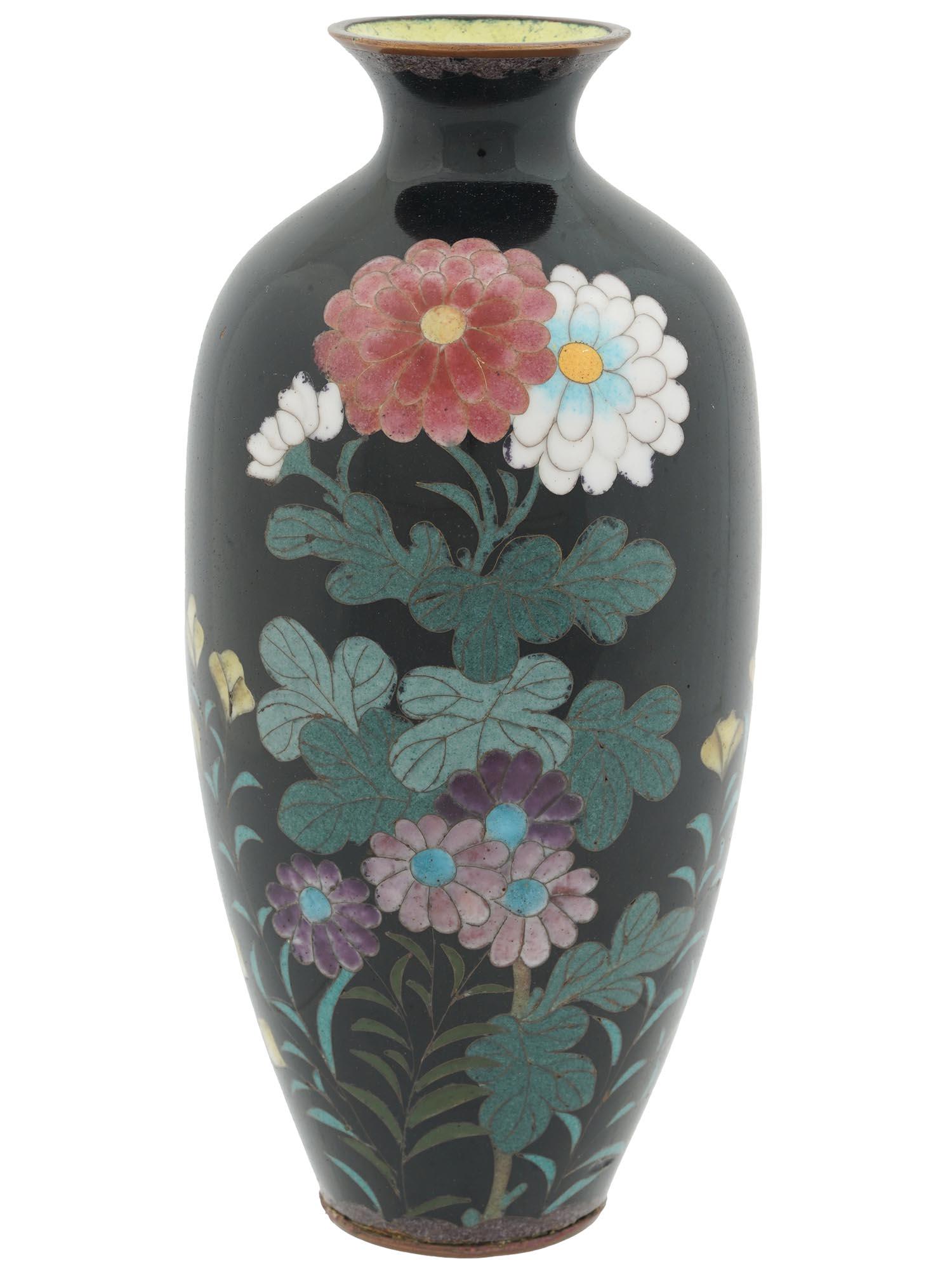 JAPANESE LATE MEIJI BLACK CLOISONNE ENAMEL VASE: An antique Japanese copper vase with cloisonne enamel design against the black background. Late Meiji period, before 1912. The vase has an elongated shape with pronounced neck. The body of the vase is