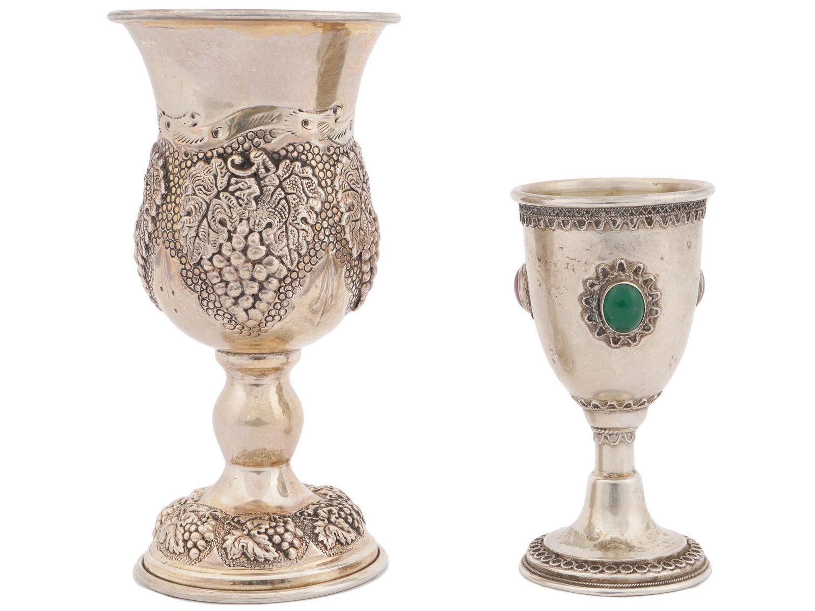 ANTIQUE AND VINTAGE JUDAICA SILVER GOBLET CUPS: Two antique and vintage silver Judaica kiddush goblet cups. The larger is decorated with chiseled clusters of grapes to the body and base, gilt inside. marked sterling silver 925. The grape theme date