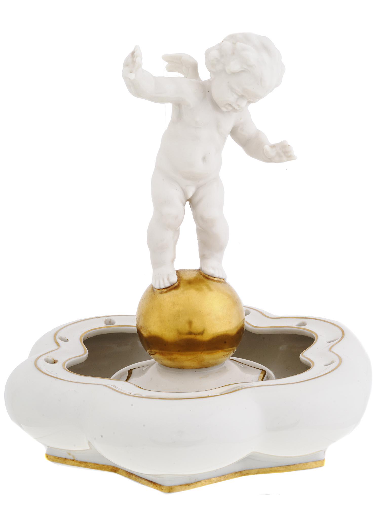 RARE GERMAN KUNSTABTEILUNG CHERUB PORCELAIN VASE: A rare vintage German Hutschenreuther Kunstabteilung figural white porcelain vase. The vase is adorned with a figurine of a Cherub balancing on a gold sphere, mounted on a base with scalloped rims, to