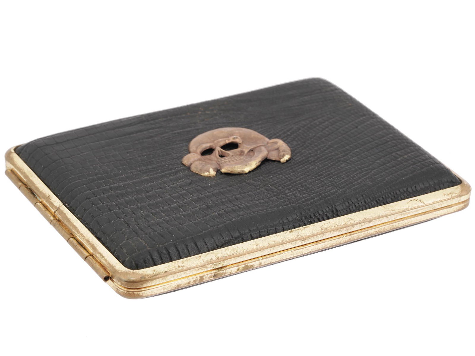 WWII NAZI GERMAN TOTENKOPF LEATHER CIGARETTE CASE: A WWII German golden metal cigarette case with a hinged lid. The outside of the case is set with black leather. The front lid is decorated with a relief Totenkopf emblem. There are two straps inside. 