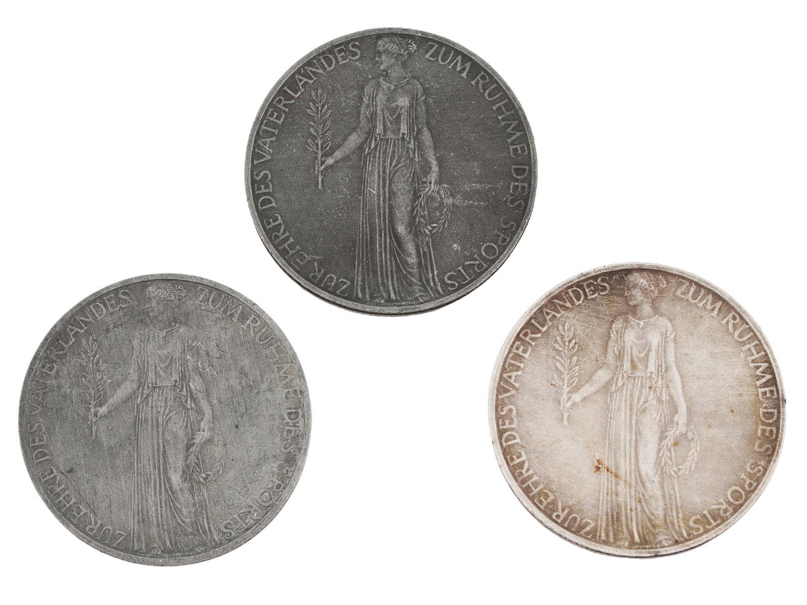 GERMAN BERLIN OLYMPIC GAMES MEDALS: A set of three 1936 Nazi German silver medals commemorating the XI Olympic Games in Berlin. The obverse features a woman in robes holding a branch and a wreath, while the reverse reads in German Olymp