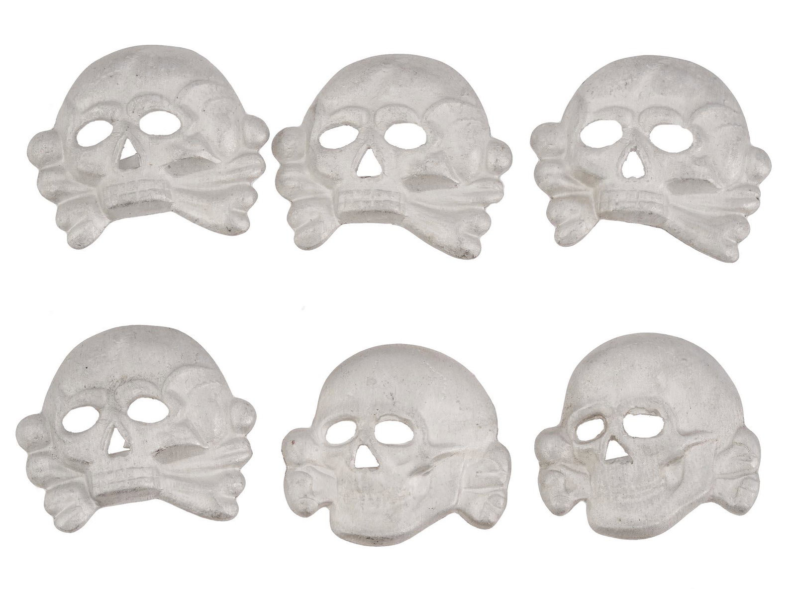 WWII NAZI GERMAN HAT BADGES FOR SS VISOR HAT SET: A WWII Nazi German Third Reich set of six metal badges for a SS visor hat. The badges are made in the shape of a Totenkopf skull swastika insignia, engraved with detailed patterns. Each is marked with