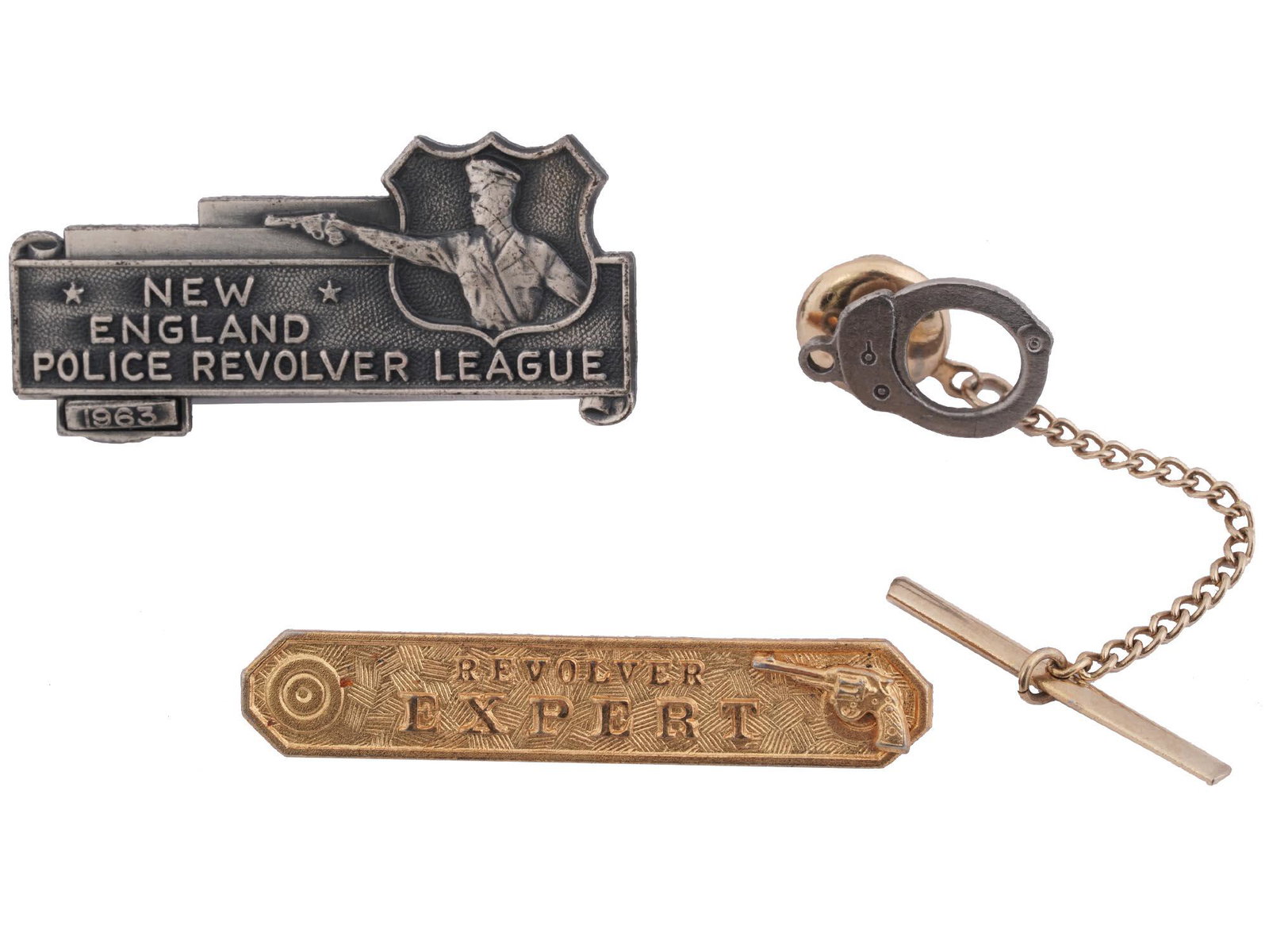 MID CENT NEW ENGLAND POLICE REVOLVER LEAGUE PINS: A lot of mid-20th century US police pins and clips. 1963 New Engand Police Revolver League pin. Revolver Exprert tie clip, marked Blackinton on the backside. A handcuff tie pin. US Historical Collecta