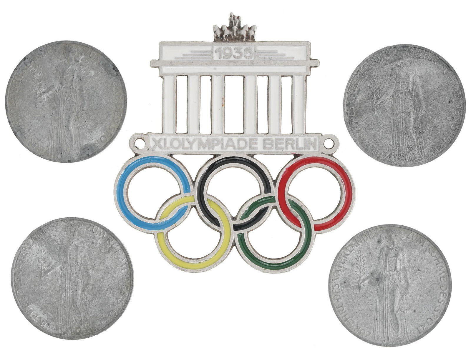 1936 BERLIN OLYMPIC GAMES CAR PLAQUE AND 4 COINS: A lot of five items related to the 1936 Summer Olympic Games in Berlin. An polychrome enameled car plaque, Brandenburg Gate with Olympic Rings and inscription XI. Olympiade Berlin 1936. Four nickel-pl