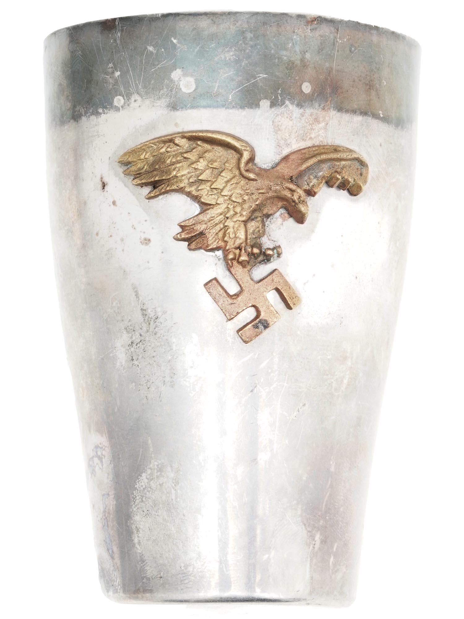 WWII GERMAN LUFTWAFFE PILOTS PRESENTATION GOBLET: A World War II German silver-plated award goblet. The vessel is garnished with a gilt Reichsadler and swastika relief. Hallmark WMF EP Brass Germany and engraved initials CP are on the bottom of the i