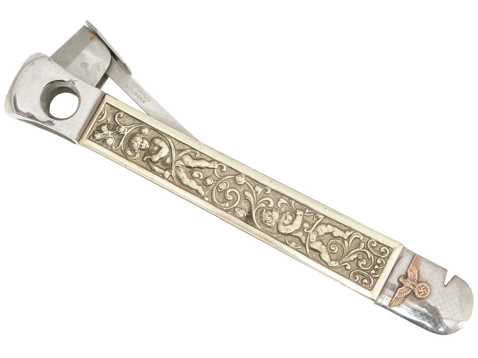 WWII GERMAN NSDAP OFFICIALS STEEL CIGAR CUTTER: A World War II German stainless steel cigar cutter. The item is decorated on the sides with brass relief depicting cherubs and flowers. A gilt Reichsadler with swastika is mounted on the front side. M