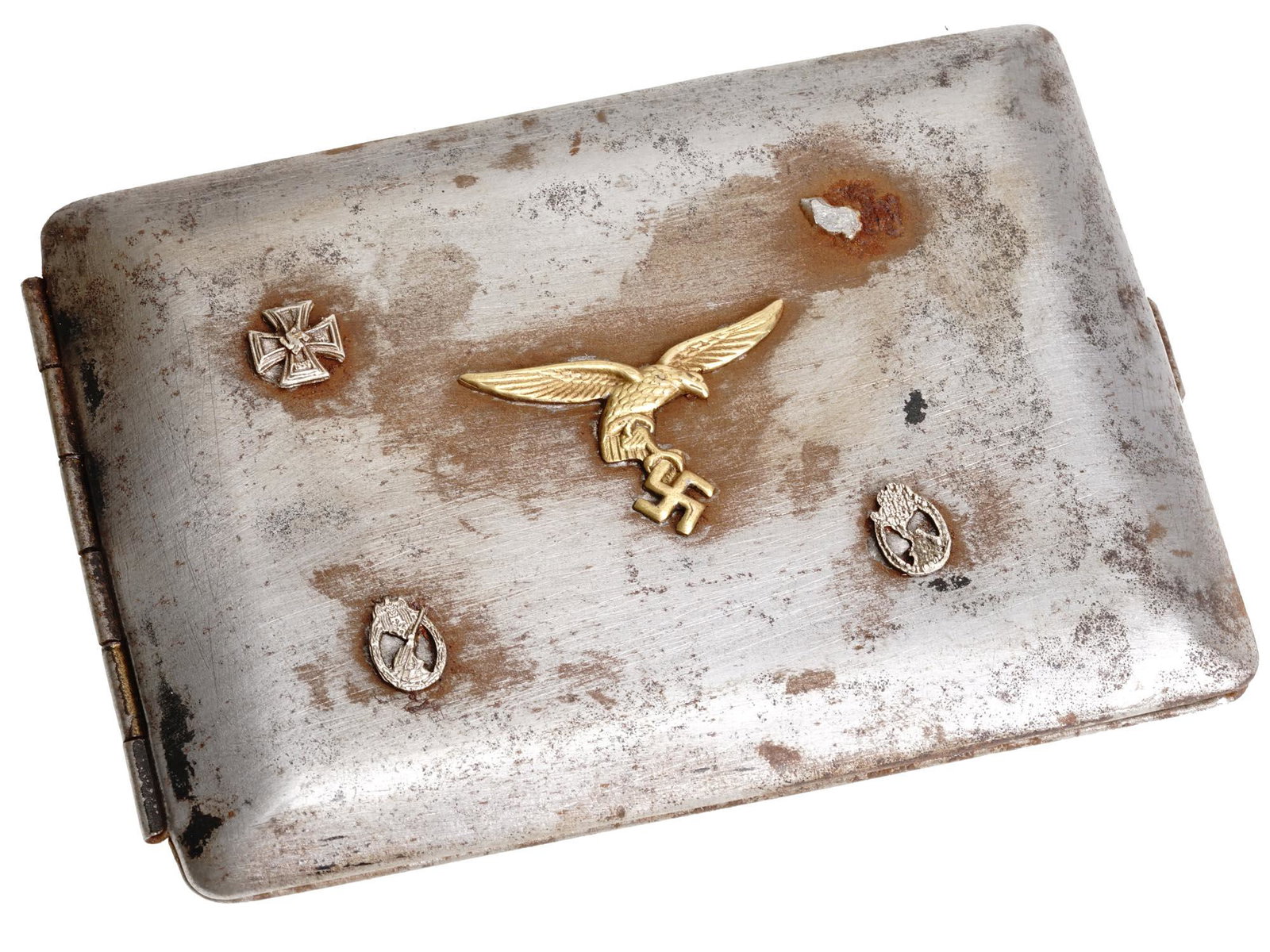 WWII NAZI GERMAN LUFTWAFFE PILOTS CIGARETTE CASE: A World War II Nazi German steel cigarette case with hinged lid. The lid is decorated with four relief symbols, gilt eagle with swastika, the 1939 Iron Cross, and two emblems of military merit. The ca