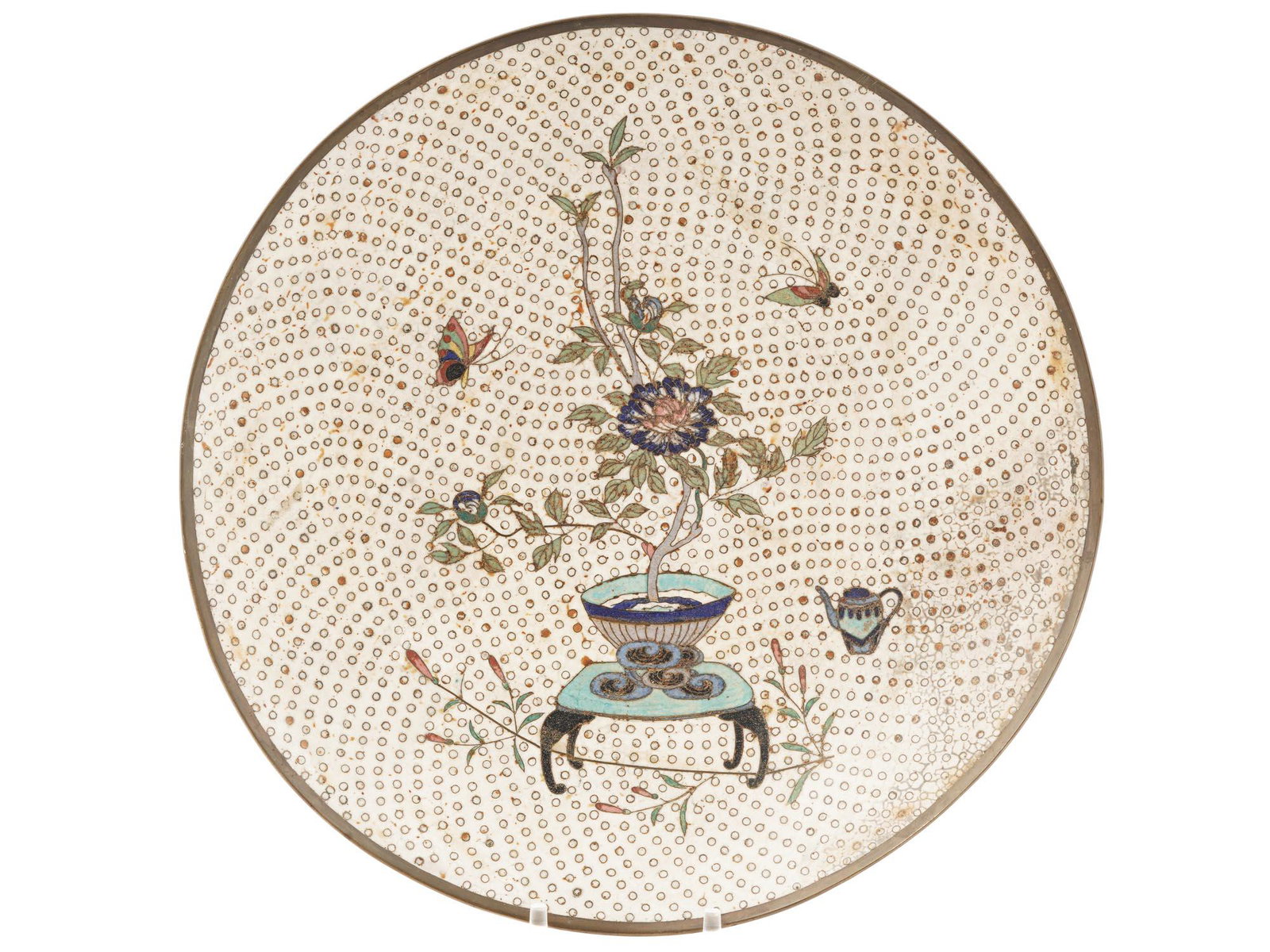 ANTIQUE JAPANESE MEIJI ERA CLOISONNE ENAMEL PLATE: An antique Japanese copper plate with cloisonne enamel design against the white polka dot background. Late Meiji period, before 1912. The central part of the plate is decorated with a pitcure of a flo