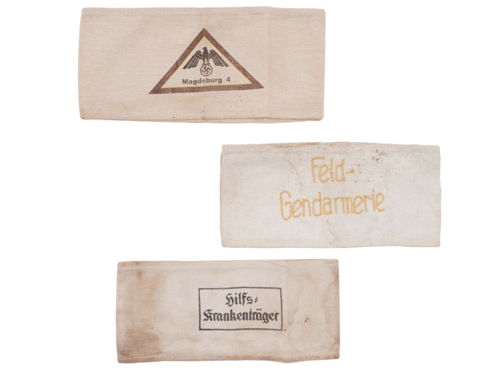 WWII NAZI GERMAN MILITARY ARMBANDS, 3 PCS: A lot of three World War II German military fabric armbands. The first has a hand-emboridered inscription Feld Gendarmerie. The second has a hand-embroidered inscription Hilfs Krankentrager, Assistant