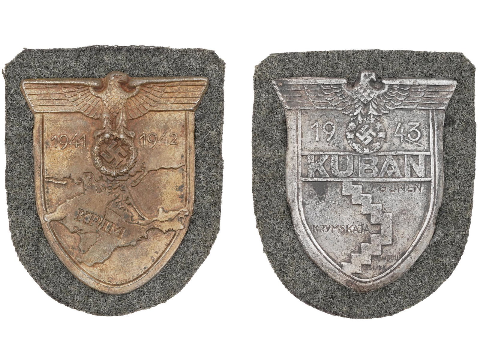 WWII NAZI GERMAN THIRD REICH CRIMEA KUBAN SHIELDS: A pair of WWII German Nazi Third Reich Military Luftwaffe metal shields. The first: a 1943 Kuban sleeve shield, inscribed in German, Kuban Lagunen Crimean Novorossiysk, and a relief image of a Nazi ea