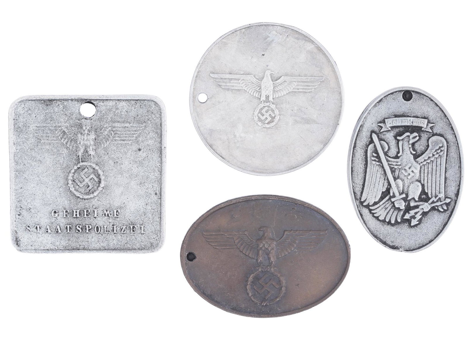 WWII NAZI GERMAN THIRD REICH IDENTIFICATION TAGS: A collection of four WWII Nazi German Third Reich Gestapo and Police Identification metal tags. The collection includes Army Secret Field Police, Prussian State Police, and Gestapo. The tags are engra