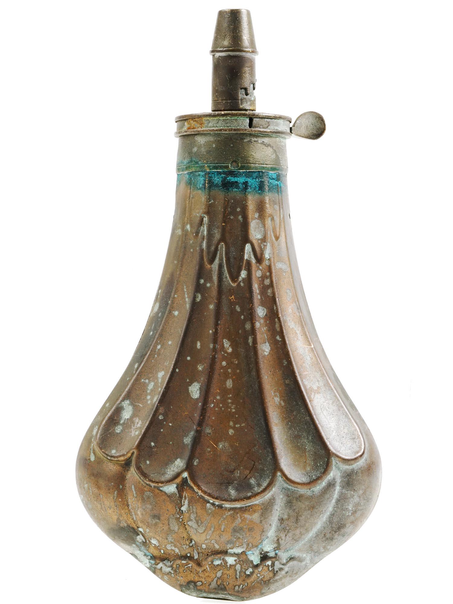 19TH CENTURY EMBOSSED BRASS POWDER FLASK FOR GUN: An antique embossed brass powder flask for a gun. The exterior is adorned with an embossed ornament made in the Art Nouveau manner. Circa: late 19th century. Antique Powder Flasks, and Military Wares 