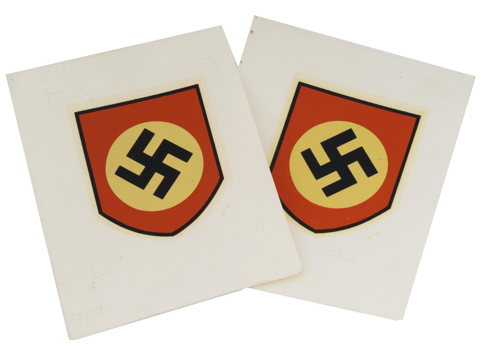 NAZI GERMAN WWII STEEL HELMET SWASTIKA DECALS: Two Nazi German WW2 steel helmet decals, each featuring a National Socialist Party shield with a swastika image in the middle. Nazi German WW2 Helmet Decals And Military Collectibles. Dimensions: Size
