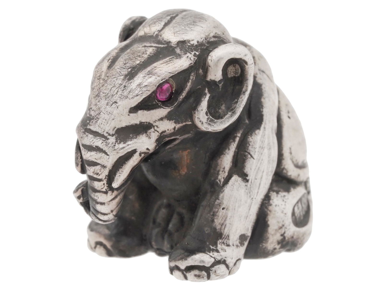 RUSSIAN SILVER ELEPHANT FIGURINE W GEM STONE EYES: A Russian silver cast figurine of a seated elephant. The figurine is well modeled, eyes are set with ruby colored gemstone cabochons. Hallmarked with an 88 silver standard, a kokoshnik mark and the ma