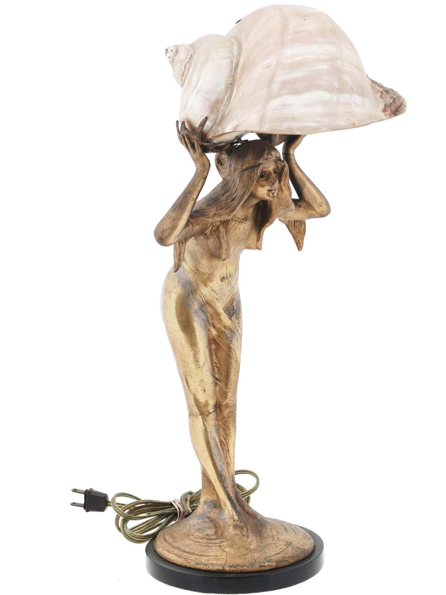 ART NOUVEAU NAUTILUS SEASHELL FIGURAL TABLE LAMP: An Art Nouveau table lamp with modern electrical fittings. The gilt spelter lamp represents a nude female figure holding a nautilus seashell lampshade above her. Collectible Home Decor And Light Fixtu