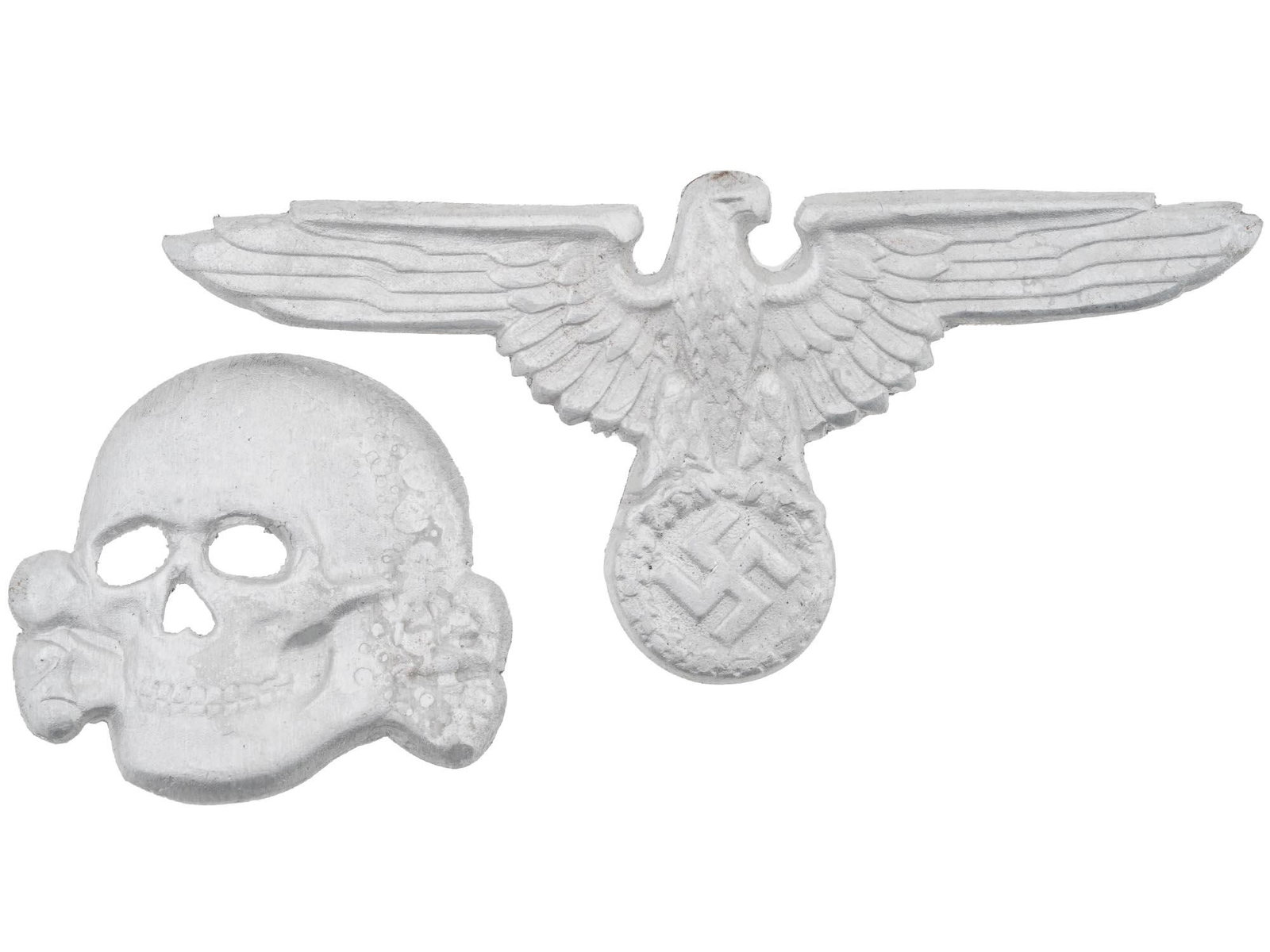 WWII NAZI GERMAN SET OF BADGES FOR SS VISOR HAT: A WWII Nazi German Third Reich set of two badges for a SS visor hat. The badges are made in a shape of a Totenkopf skull and an eagle swastika insignia. marked with Ges Gesch and RZM marks, on the bac