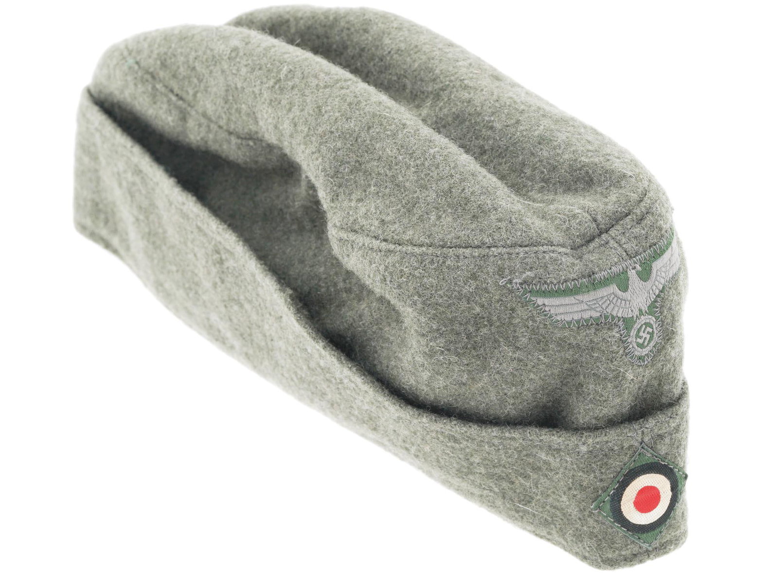 WWII ERA NAZI GERMAN THIRD REICH SOLDIER SIDE CAP: A WWII era Nazi German Third Reich olive grey wool side cap with a machine applied Eagle with swastika and insignia of tank forces are on the front. A beige lining is stamped, Clemens Wagner, DEZ 42, 