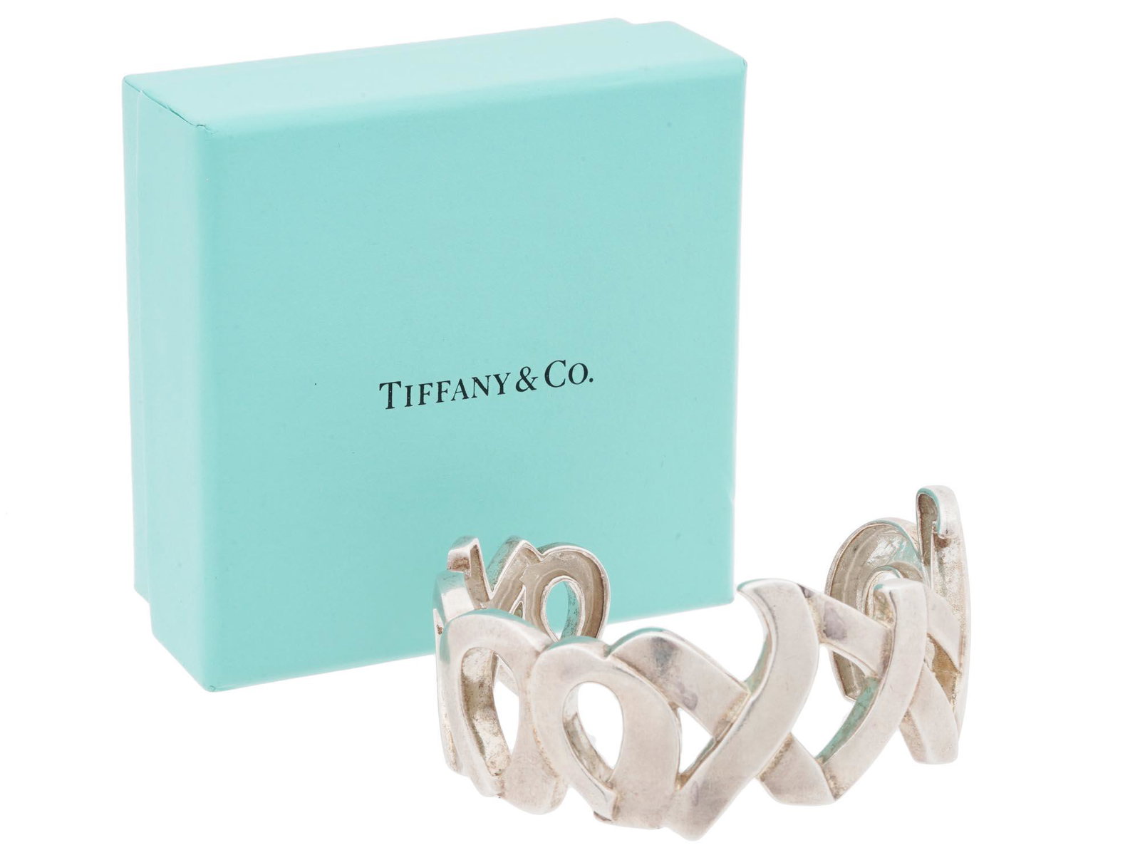 TIFFANY CO STERLING SILVER CUFF BY PALOMA PICASSO: A Tiffany and Co 925 Sterling Silver cuff designed by Paloma Picasso. The ring is made in an openwork XO design all the way around. Marked with a Sterling Silver hallmark, a Tiffany and Co mark, and a