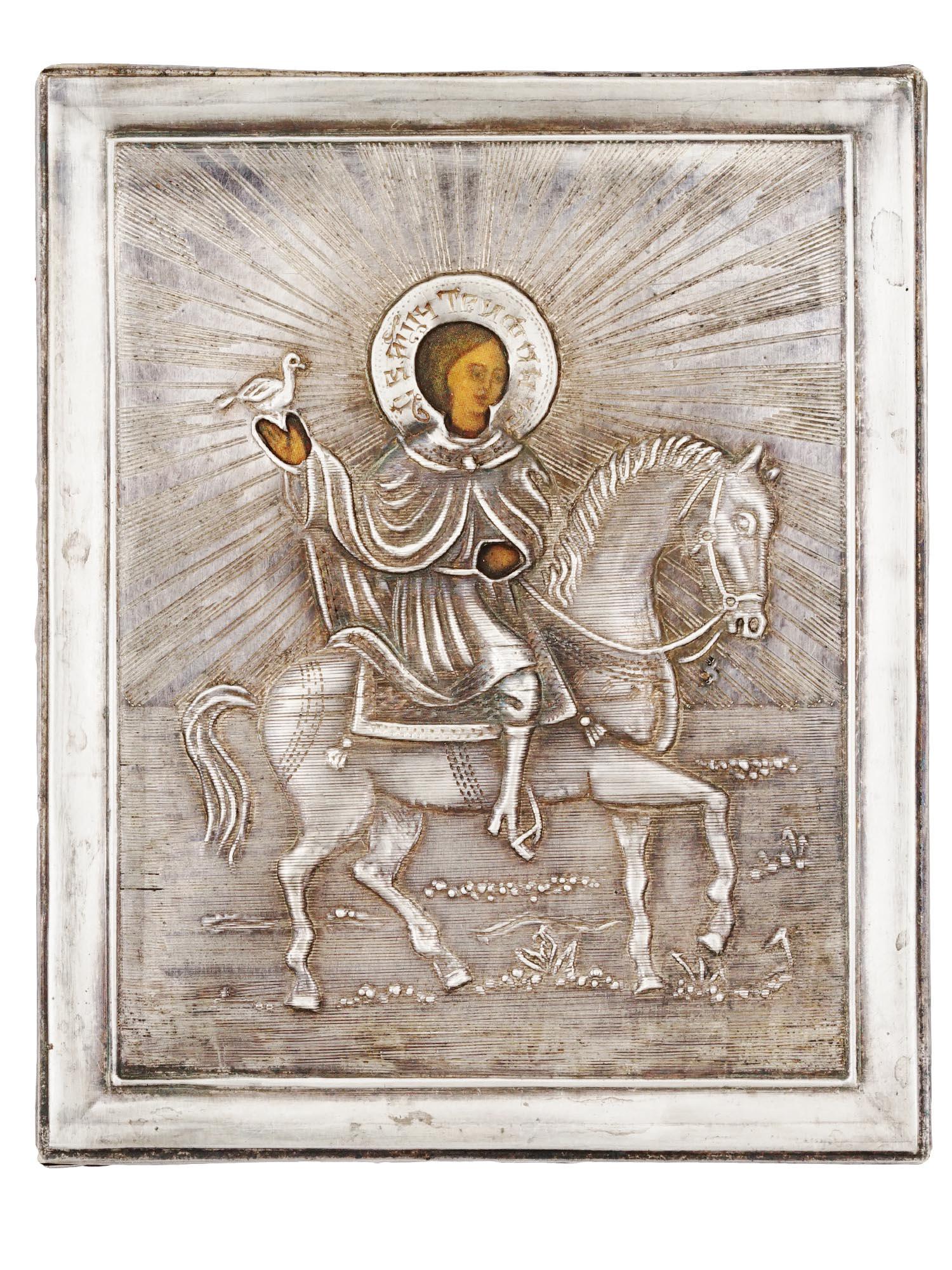 RUSSIAN TRAVEL SAINT TRYPHON ICON IN SILVER OKLAD: A Russian Orthodox travel icon of Saint Tryphon. The mixed media painting: egg tempera, gesso, and levkas on a wood board. The icon is overlaid with a Silver oklad or riza, adorned with repousse decor