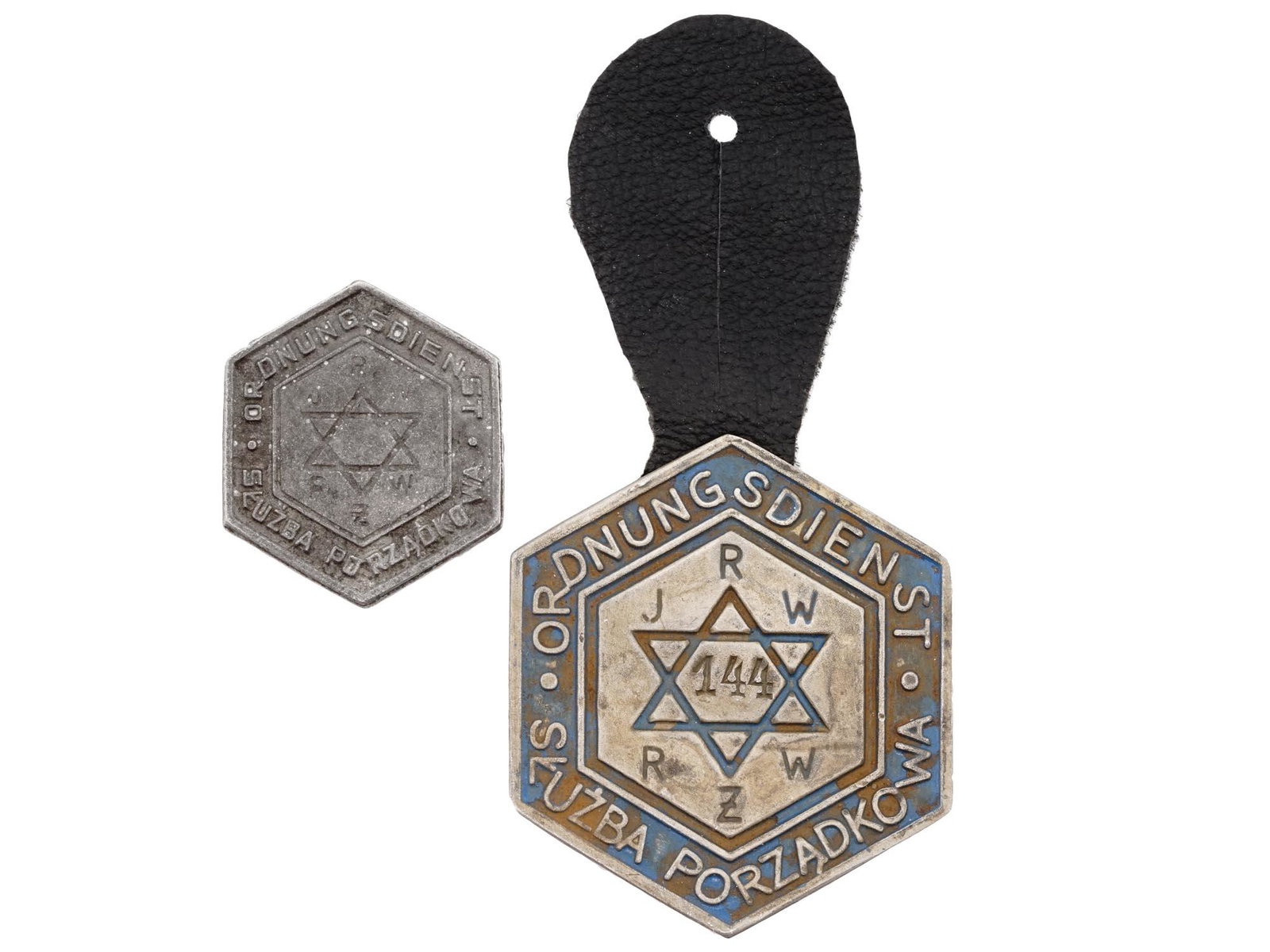 PAIR OF WWII WARSAW JEWISH GHETTO POLICE BADGES: A pair of World War II Polish metal breast badges of Warsaw ghetto police. Hexagonal badges with Magen David, inscriptions Ordnungsdienst Sluzba Porzadkowe, JRW RZW. The bigger badge has leather backi