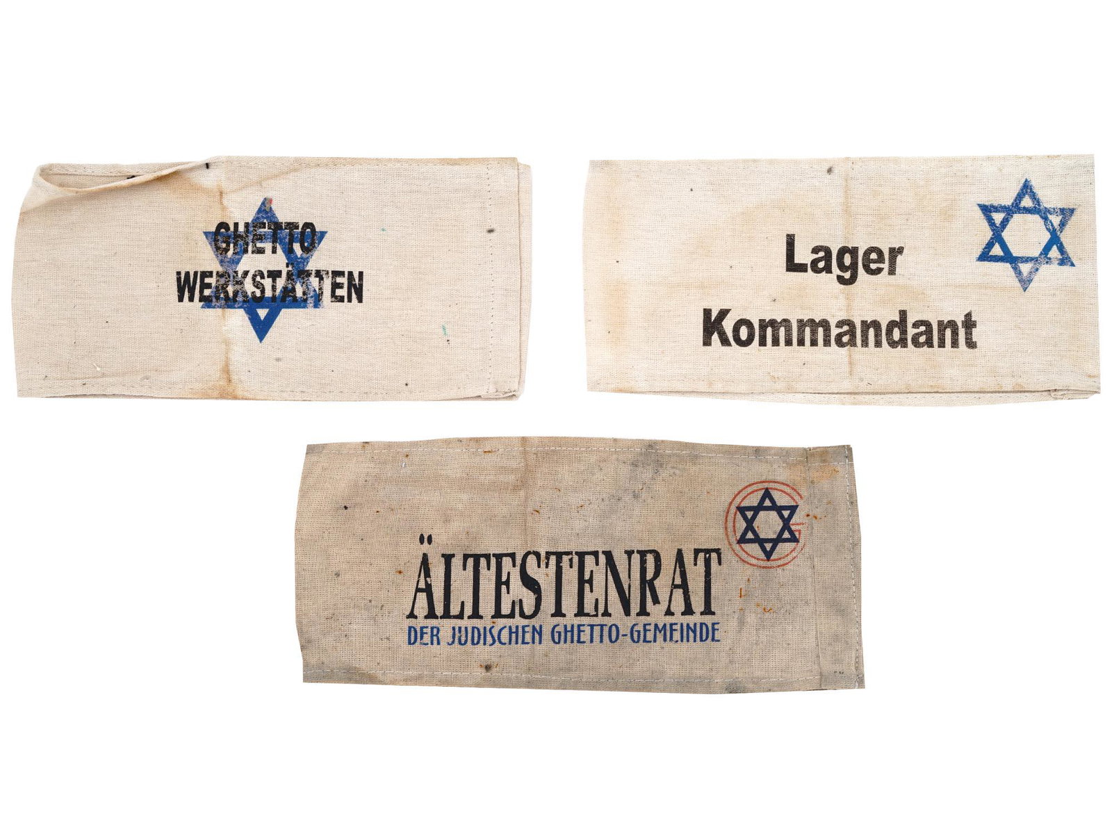 WWII HOLOCAUST CONCENTRATION CAMP ARMBANDS 3 PCS: Three WWII Jewish concentration camp fabric armbands. The first has a Magen David and inscription Ghetto Werkstatten, Ghetto Workshops. The second has a Magen David with inscription Lager Kommandant, 