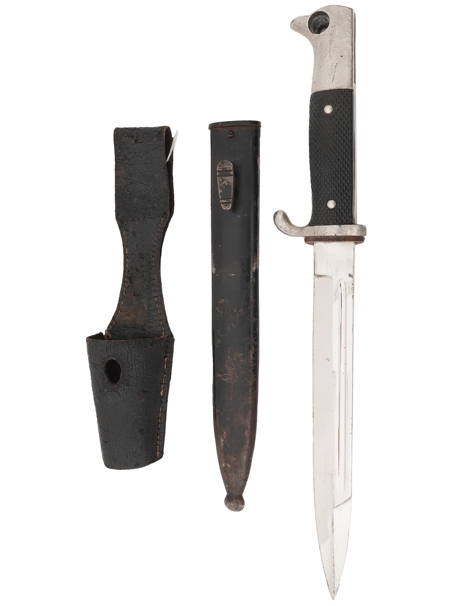 WWII NAZI GERMAN CLOSE COMBAT KNIFE IN SHEATH: A World War II German close combat knife, the Nahkampfmesser. Stainless-steel blade, black bakelite handle. Steel and leather scabbard. Snake trademark is on the blade by the handle. The German combat