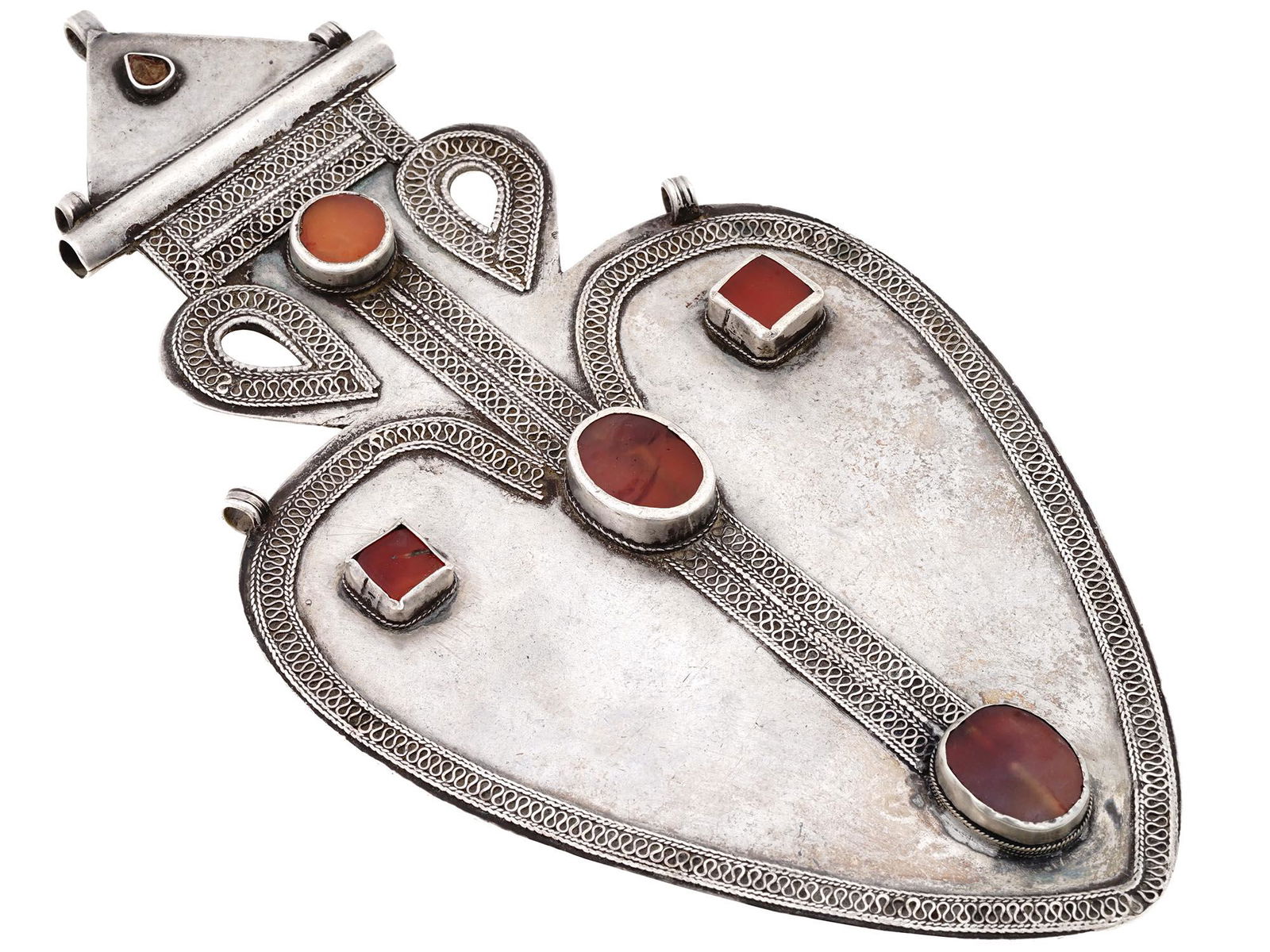 ANTIQUE TURKMEN CORDIFORM ASYK SILVER PENDANT: A fine antique Turken heart shaped Asyk amulet pendant comprised of silver decorated with a silver filigree wire and set in raised bezels with table-cut carnelians. Circa 1900. Vintage And Antique Han