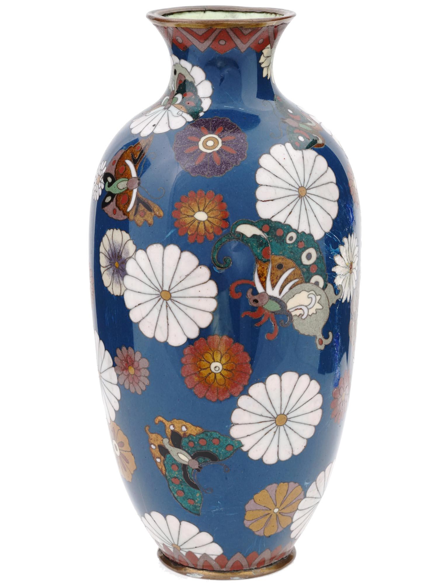 ANTIQUE JAPANESE MEIJI ERA CLOISONNE ENAMEL VASE: An antique Japanese Meiji era amphora shaped enamel over brass vase. The exterior of the vase is enameled with polychrome images of blossoming flowers, and butterflies made in the Cloisonne technique.