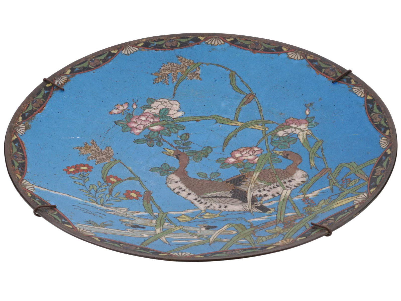 ANTIQUE JAPANESE MEIJI CLOISONNE ENAMEL CHARGER: An antique Japanese late Meiji era enamel over metal charger plate. The plate is enameled with a polychrome image of naturalistic ducks sitting on branches with blossoming flowers on blue ground made 