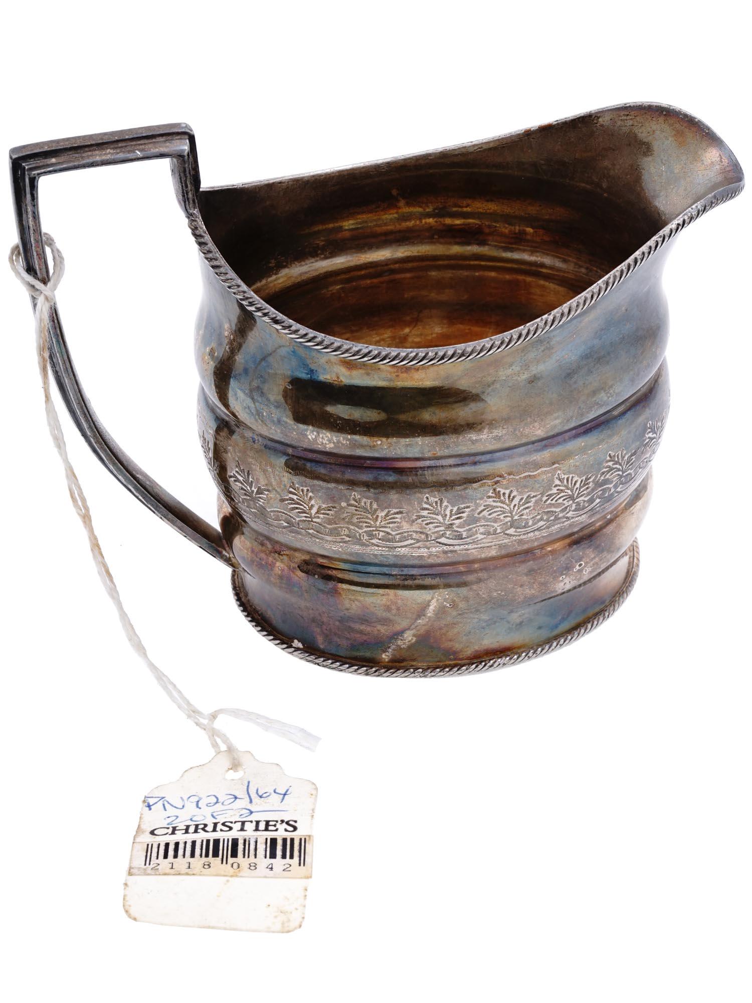 ANTIQUE ENGLISH GEORGIAN STERLING SILVER CREAMER JUG: An antique English Georgian sterling silver cream jug featuring an engraved floral design to the body, with twisted outer rims and a pointed vertical handle. No hallmarks. Antique Silver Serveware And