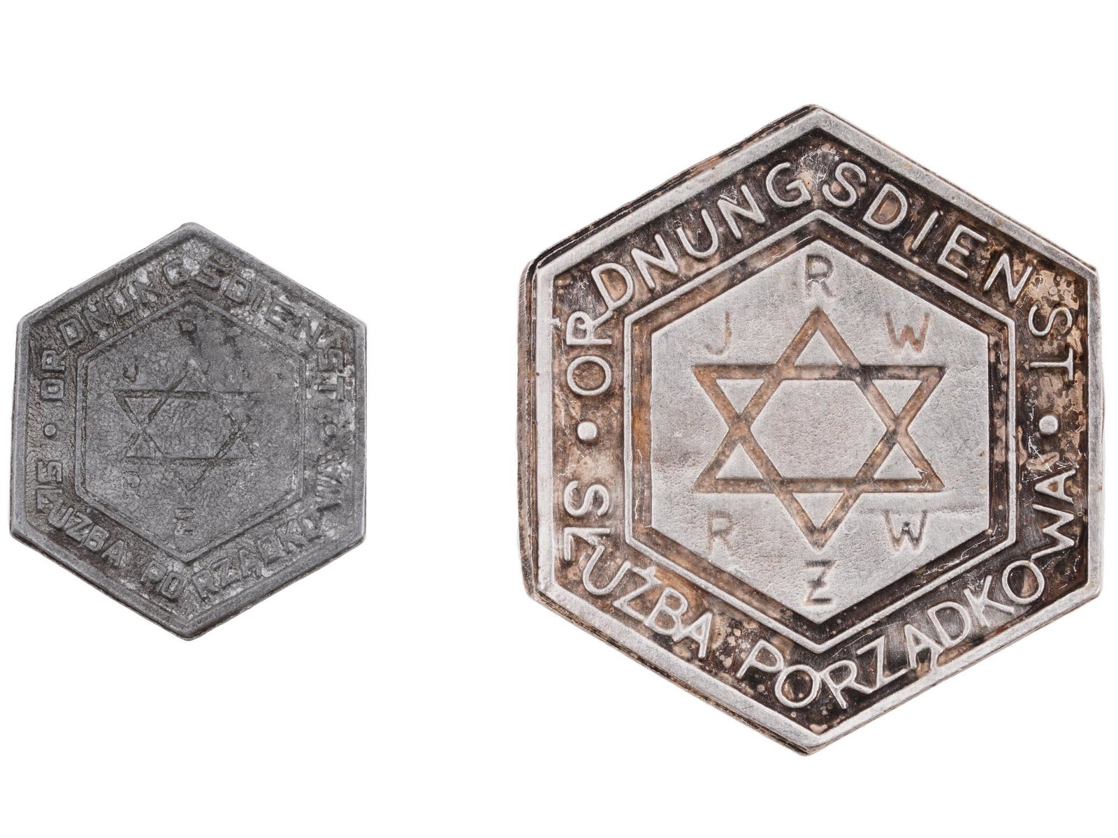 SET OF 2 WARSAW GHETTO POLICE BADGES: A pair of World War II Polish metal breast badges of Warsaw ghetto police. Hexagonal badges with Magen David, inscriptions Ordnungsdienst Sluzba Porzadkowe, JRW RZW. The smaller badge is marked RZM. T