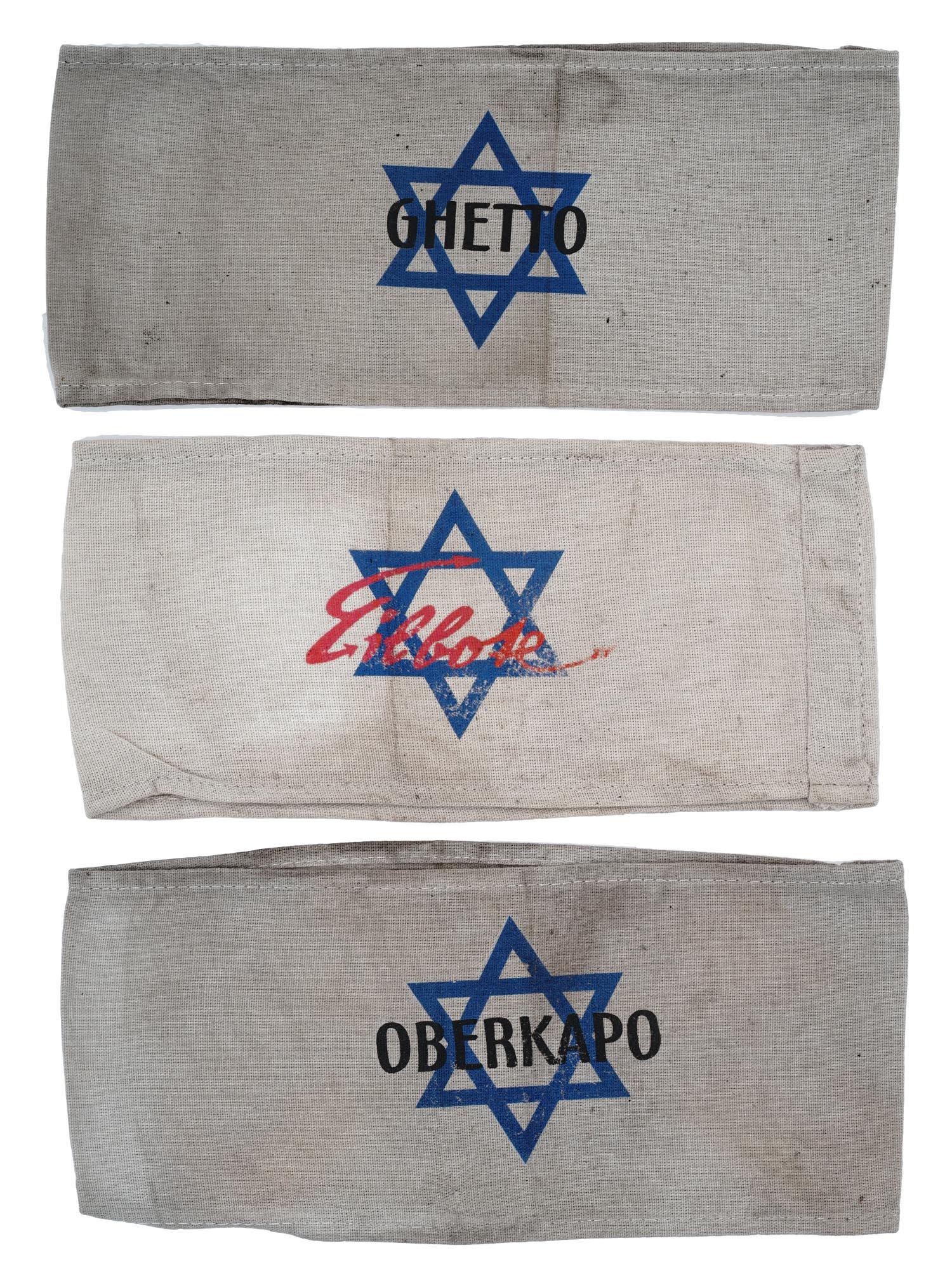 GROUP OF 3 HOLOCAUST JEWISH GHETTO ARMBANDS: A collection of three World War II Jewish Holocaust Ghetto armbands. The collection includes a Ghetto messenger armband, a Ghetto armband, and an Oberkapo, Kapo in Chef. The word kapo designates the p
