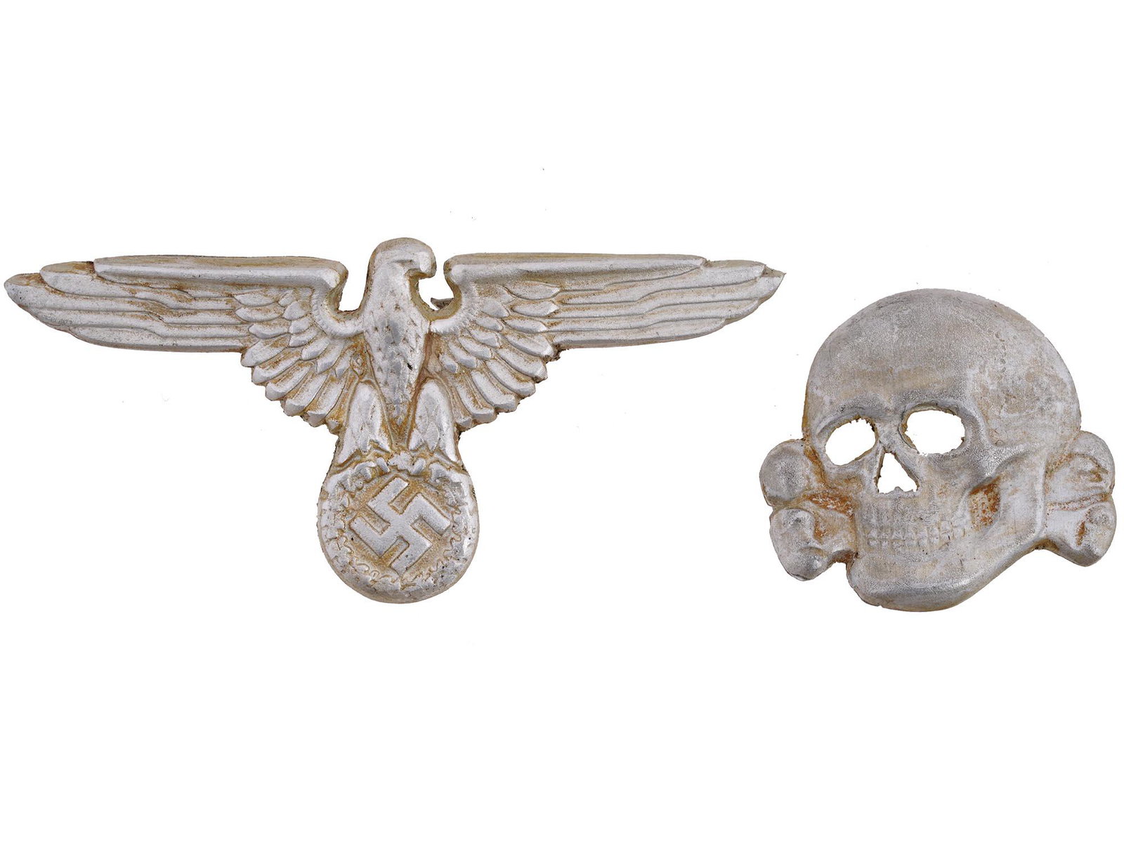 WWII NAZI GERMAN SET OF BADGES FOR SS VISOR HAT: A WWII Nazi German Third Reich set of two badges for a SS visor hat. The badges are made in a shape of a Totenkopf skull and an eagle swastika insignia. Marked with Ges Gesch and RZM marks, on the bac