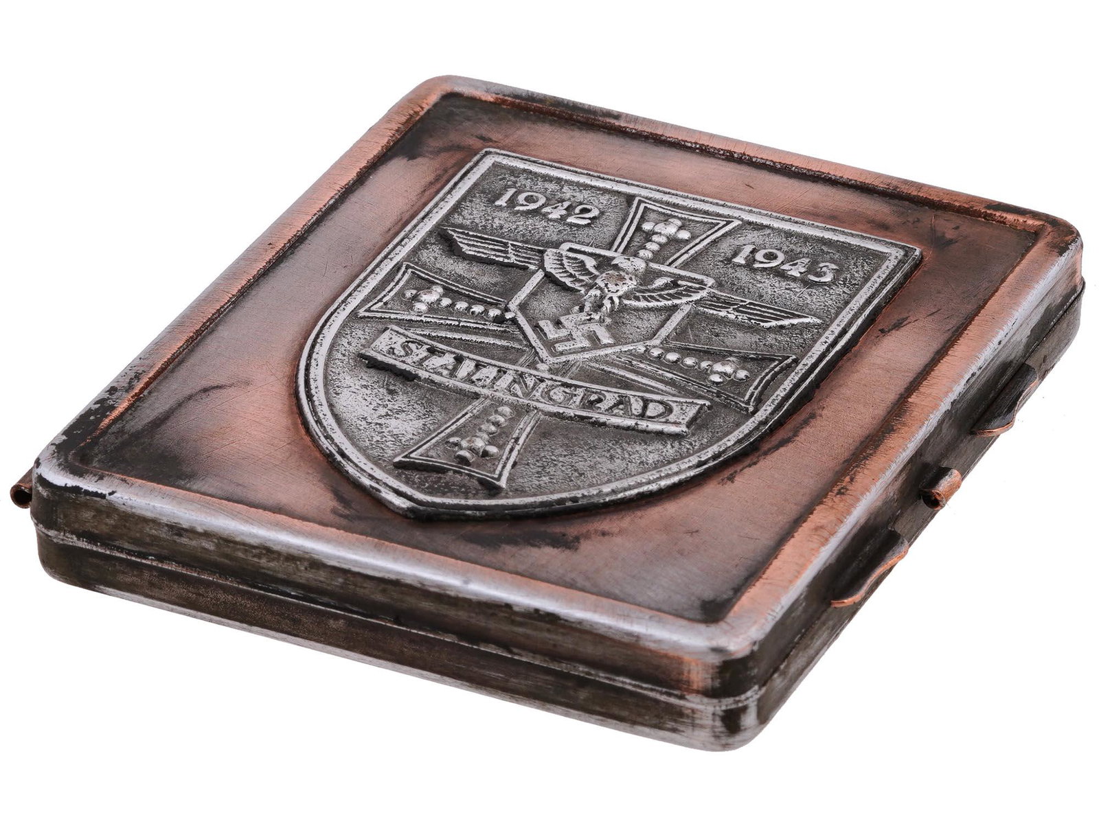 GERMAN WWII BATTLE FOR STALINGRAD CIGARETTE CASE: A World War II German stainless steel cigarette case. The front cover is decorated with an embossed coat of arms which presents th German cross, Reichsadler with swastika, inscriptions 1942-1943, Stal