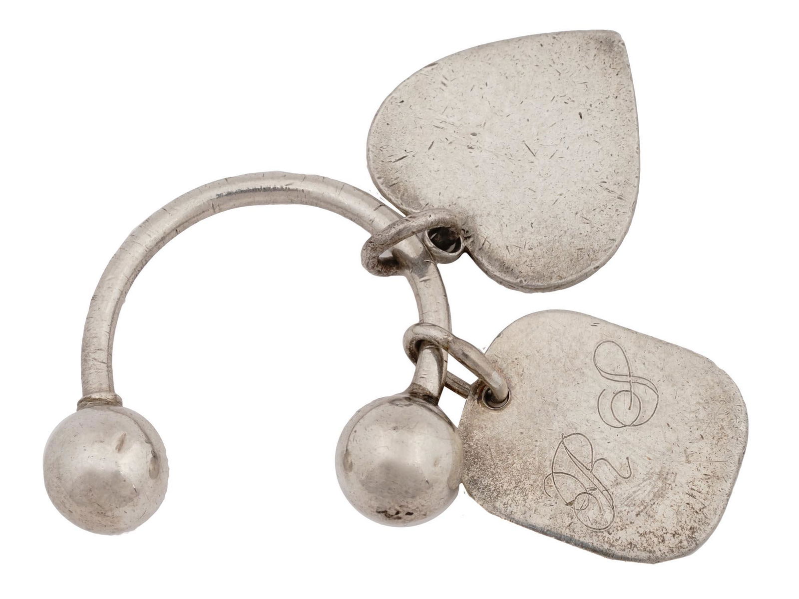 STERLING SILVER KEYCHAIN BY TIFFANY CO AND CARTIER: A Tiffany and Co Sterling Silver welcome keychain with a heart shaped tag, marked with a Tiffany and Co and a Sterling Silver hallmark. Completed with a rectangular shaped tag, marked, Cartier, and et