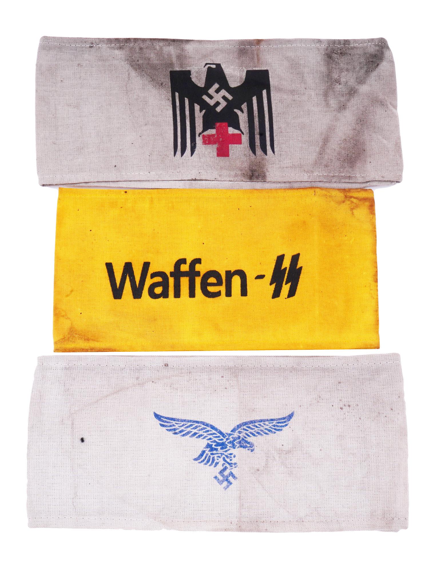 SET OF THREE WWII NAZI GERMAN THIRD REICH ARMBANDS: A collection of three WWII Nazi German Third Reich textile armbands including a band with a blue Luftwaffe Reichsadler, a yellow armband marked Waffen SS, and a red cross armband with swastika and Rei